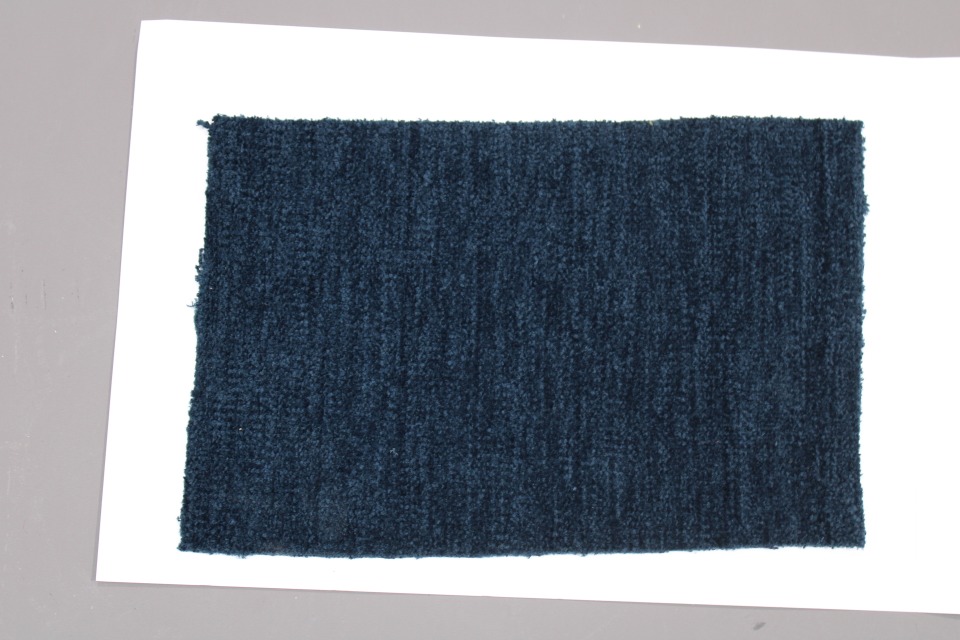 Stoffmusterkarte Gruppe 81 Cor: Nahaufnahme eines dunkelblauen, texturierten Möbelstoffes für Polster und Dekoration.