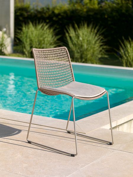 Weishäupl Slope Chair Outdoor Stuhl mit hellgrauem Sitzkissen vor Pool. Gartenmöbel für Terrasse.
