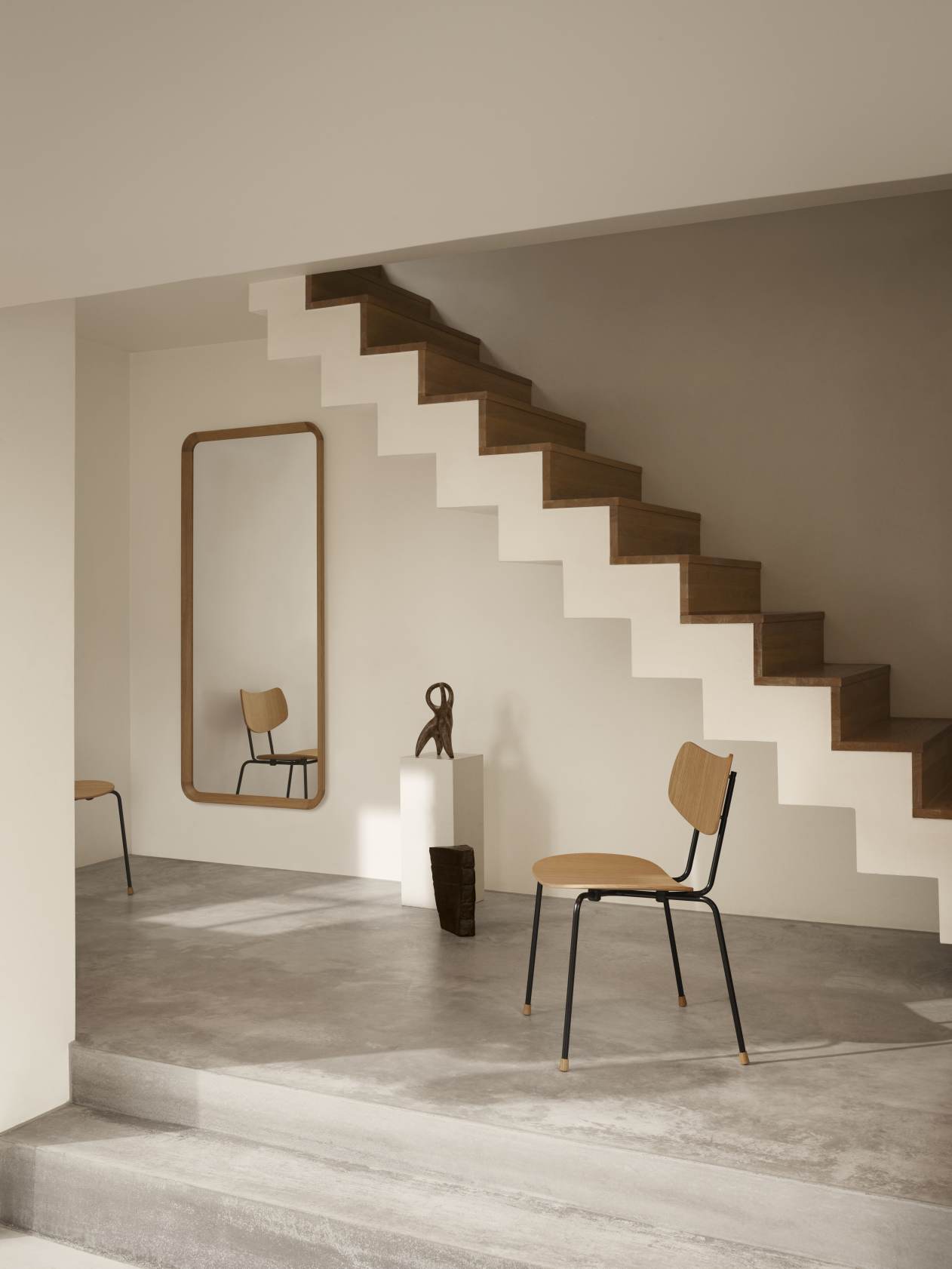 VLA62 Radio House Mirror von Carl Hansen & Søn in modernem Interieur mit Treppe und Stuhl.