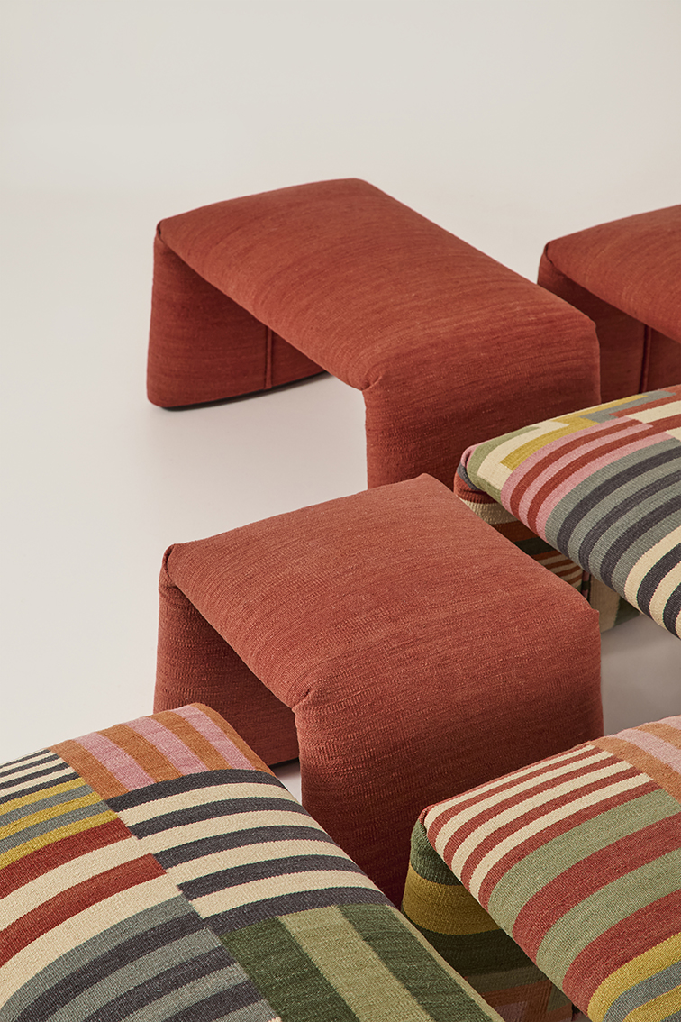 Nanimarquina Folded Colors Bank, safranrote Sitzbank und gestreifte Kissen, moderne Wohnaccessoires.