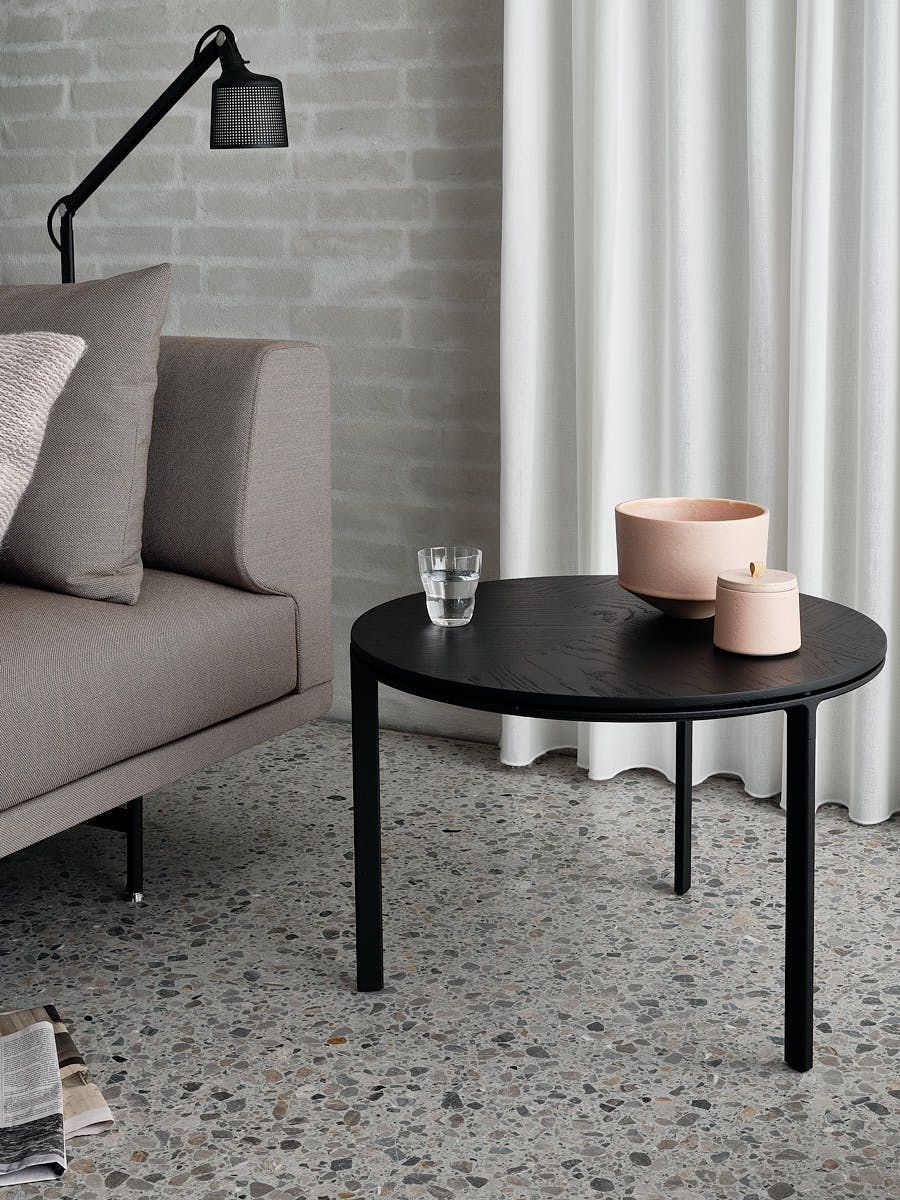 Schwarzer Vipp Couchtisch Ø60 mit Glas, Keramikschale und Kerze im modernen Wohnzimmer. Runder Beistelltisch.