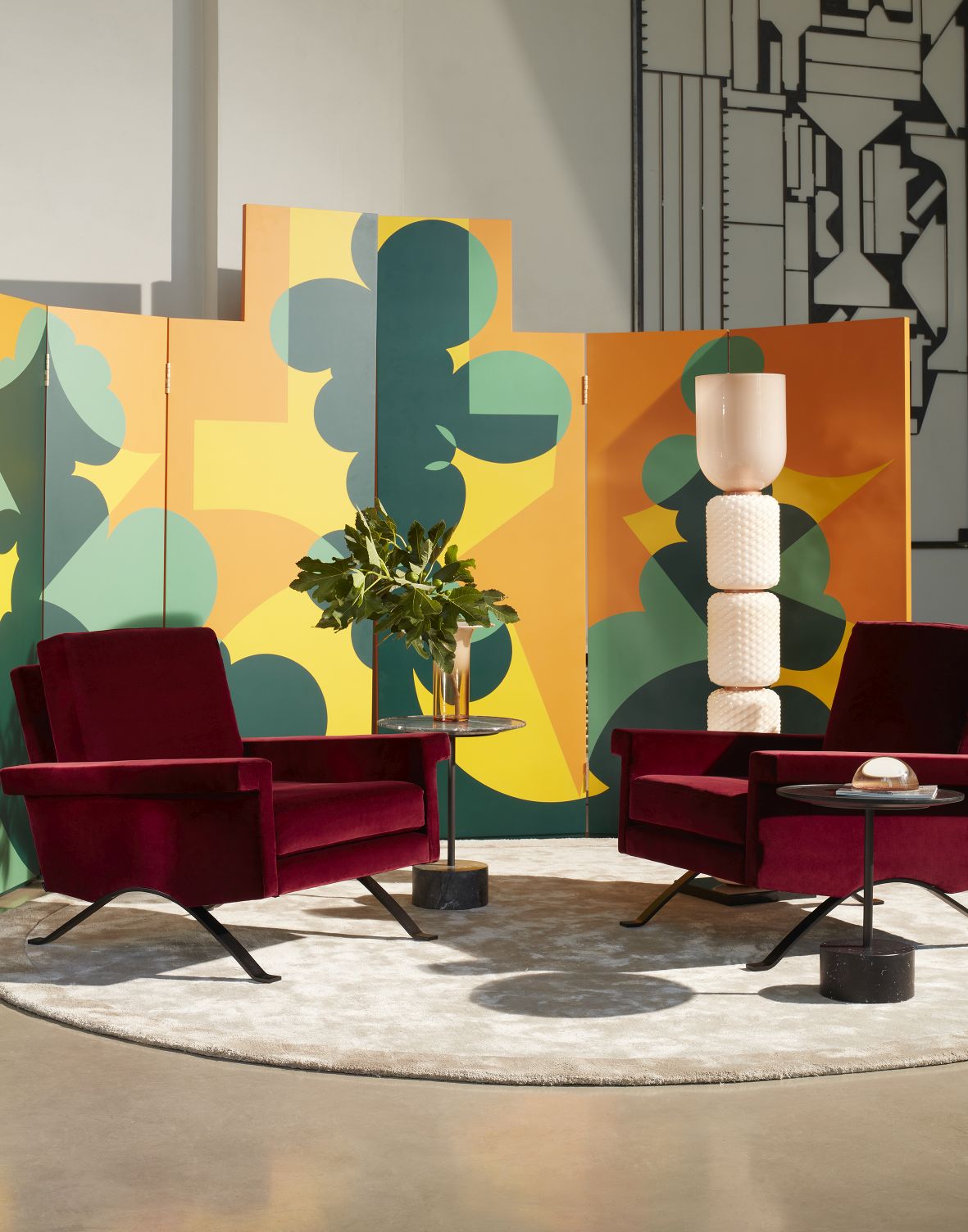 Innenraum mit zwei roten Sesseln und Cassina Ficupala Stehleuchte im Hintergrund.