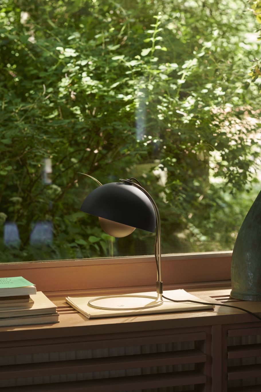 Schwarze FlowerPot Tischleuchte von AndTradition auf einem Fensterbrett, modernes Design, stimmungsvolle Beleuchtung.