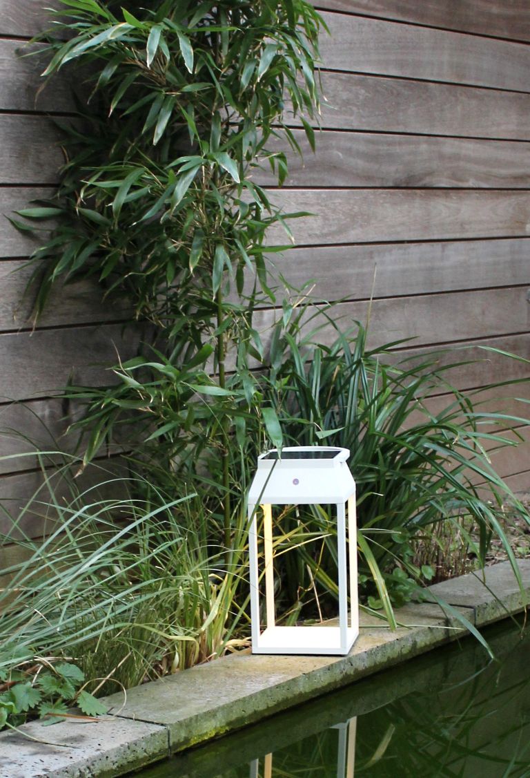 Weiße Louis Solar Laterne von Moree im Garten am Teich.
