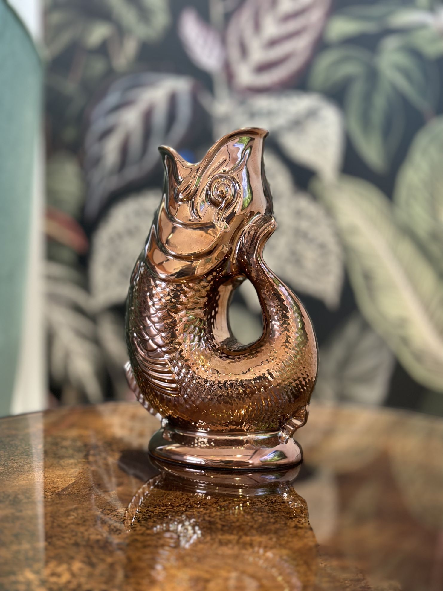Nahaufnahme einer kupferfarbenen Gluckigluck Fischkaraffe auf einem Tisch, dekorative Wasserkaraffe.