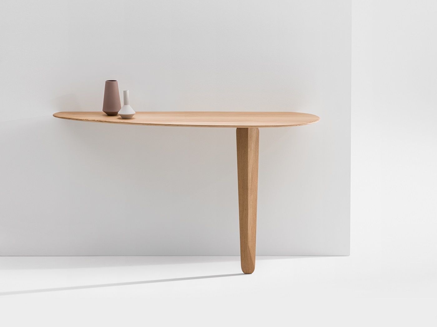 Kuyu Console: Asymmetrischer Konsoltisch aus hellem Holz mit zwei Vasen als Dekoration.