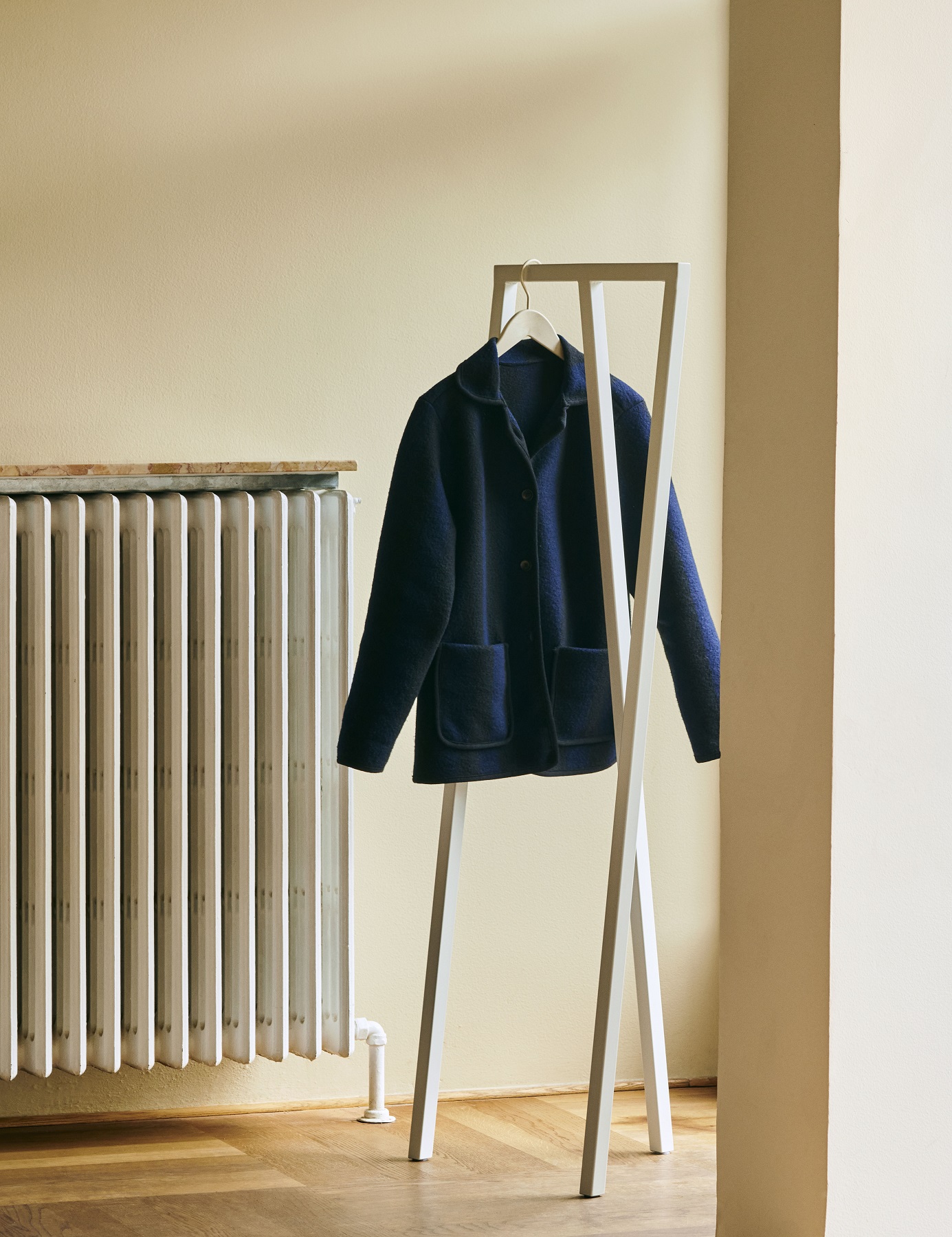 Weißer Loop Stand Hall Kleiderständer von Hay mit Jacke, minimalistisches Design für Flur und Garderobe.