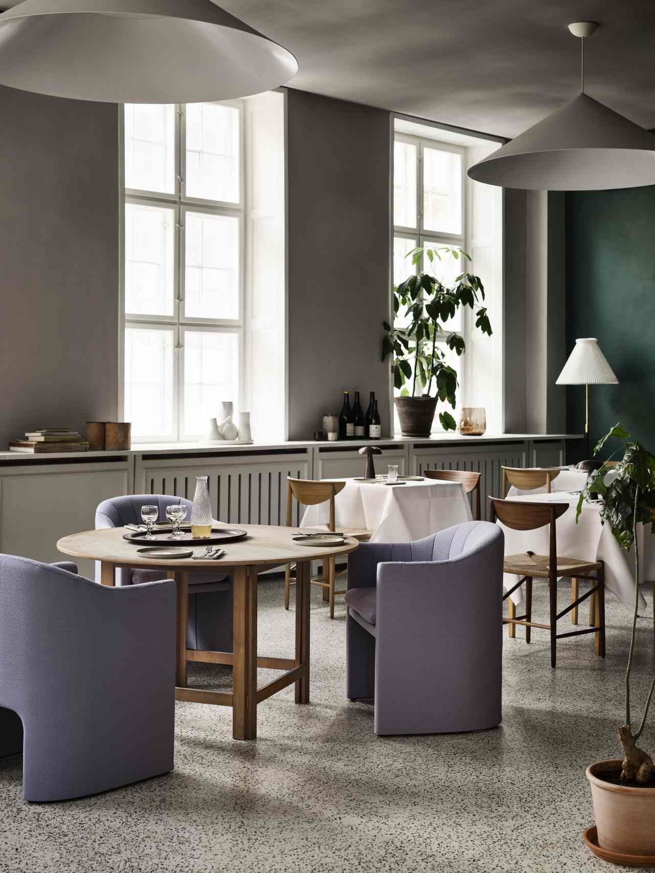 Esszimmer mit runden Holztisch und grauen Loafer Sesseln von AndTradition. Designermöbel für stilvolles Wohnen.