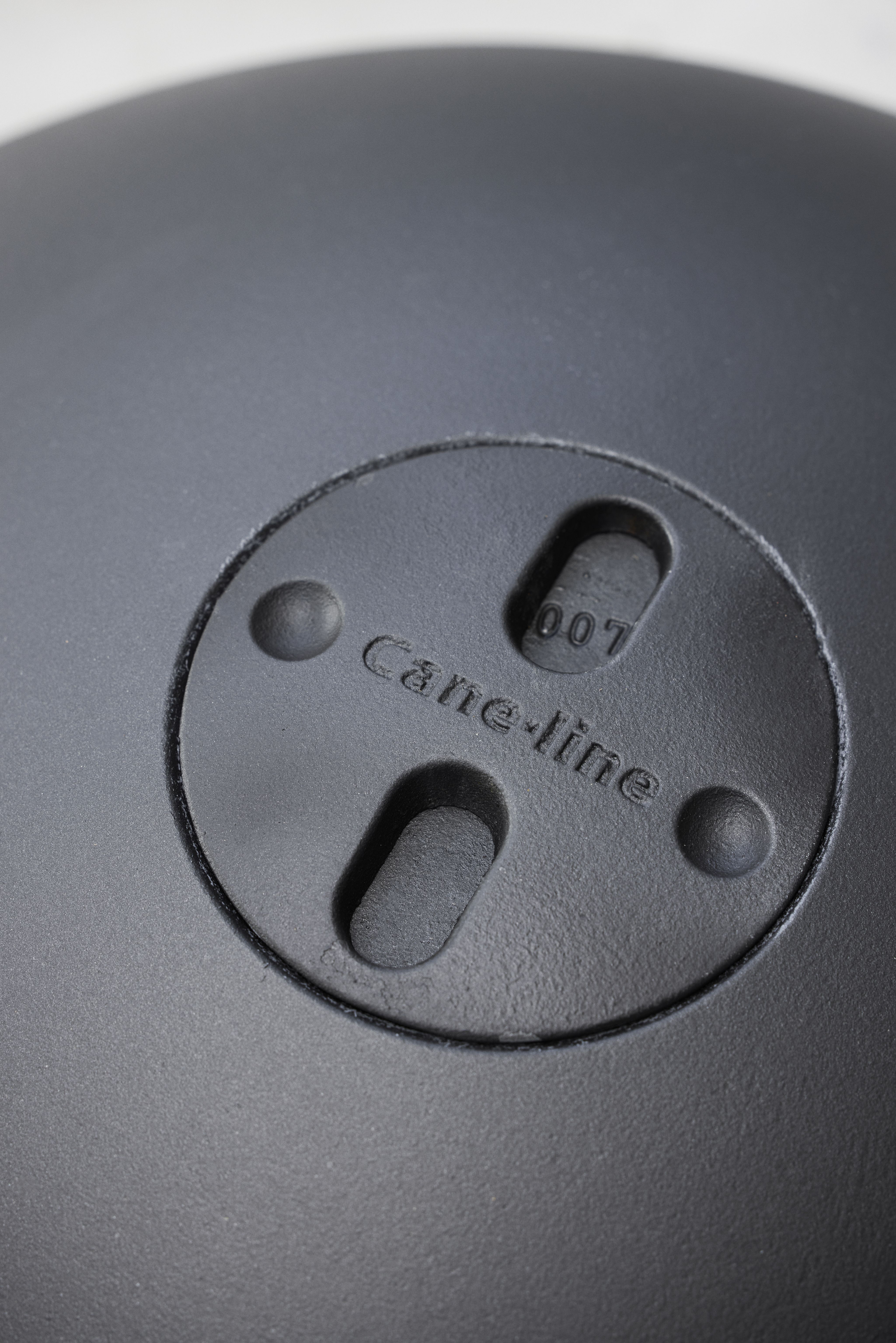 Detailaufnahme des Cane-Line Ember Feuerschalen Deckels mit Logo und Lüftungsschlitzen.