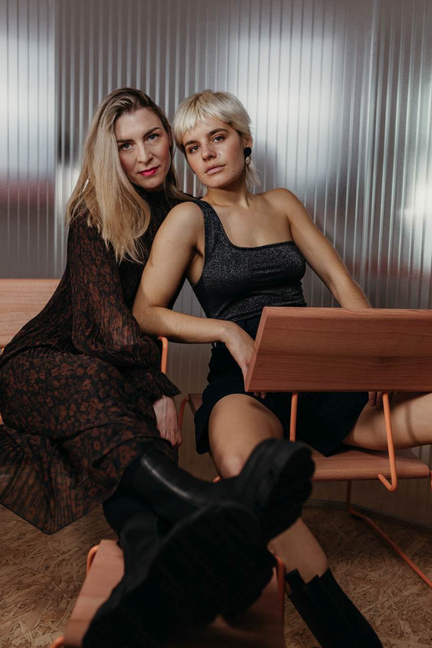 Zwei Frauen sitzen auf dem D:007 Loungechair von Fuchs & Habicht. Moderner Designstuhl.