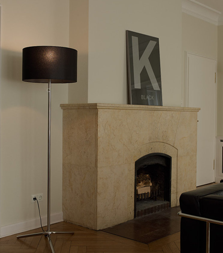 Baton Stehleuchte von Tecnolumen mit schwarzem Schirm und Chromgestell im Wohnzimmer.