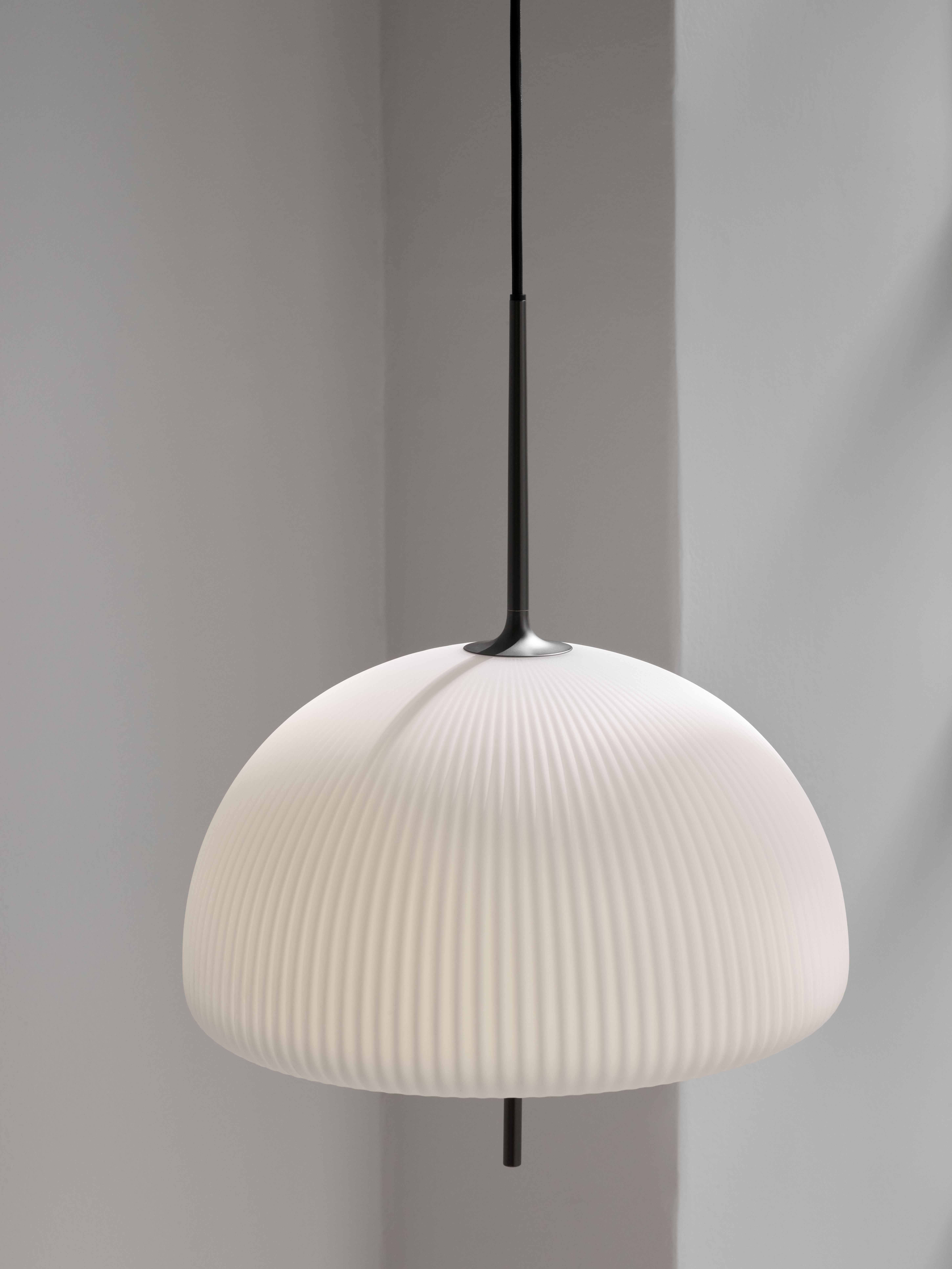 Nahaufnahme der Vipp Sculpture Pendelleuchte: Weißer, gerippter Lampenschirm mit schwarzer Aufhängung.
