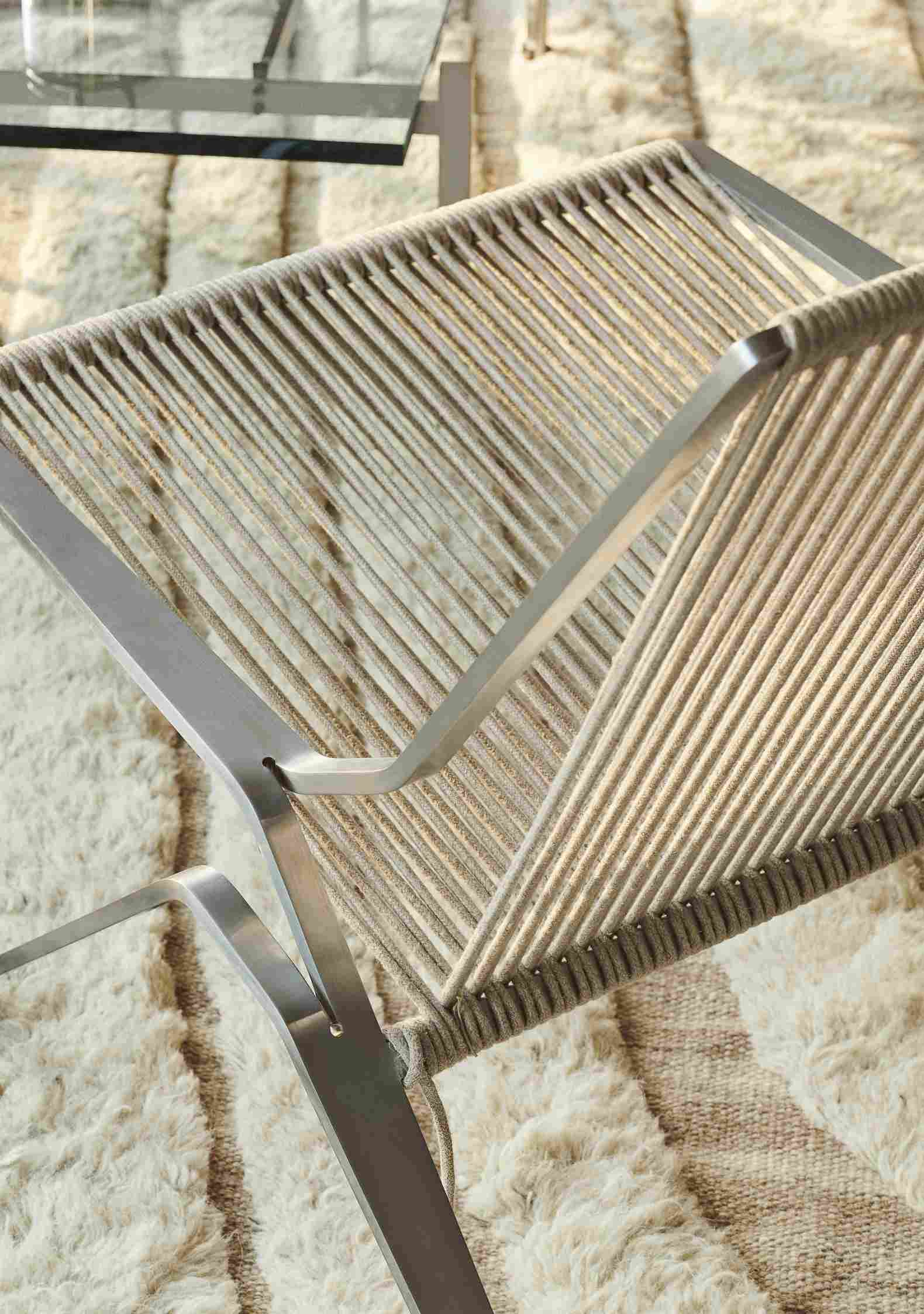 Detailaufnahme des PK25 Sessels von Fritz Hansen, Designklassiker mit Stahlrahmen und geflochtener Sitzfläche.