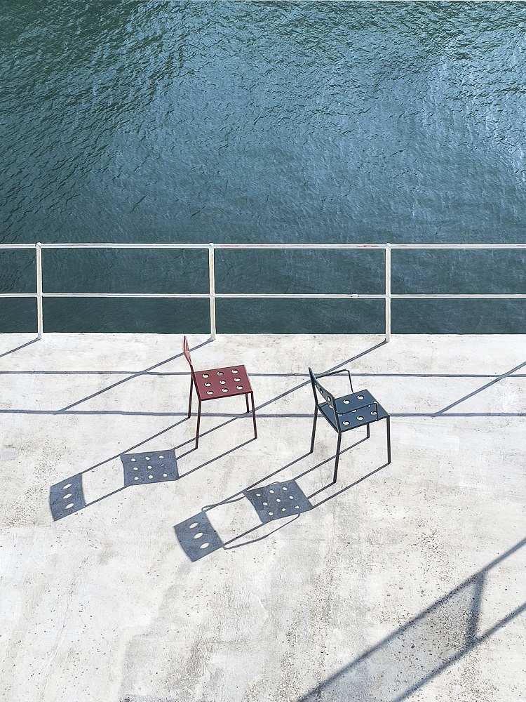 Anthrazitfarbener Balcony Outdoor Chair Stuhl von Hay auf einer Terrasse mit Blick auf das Wasser.