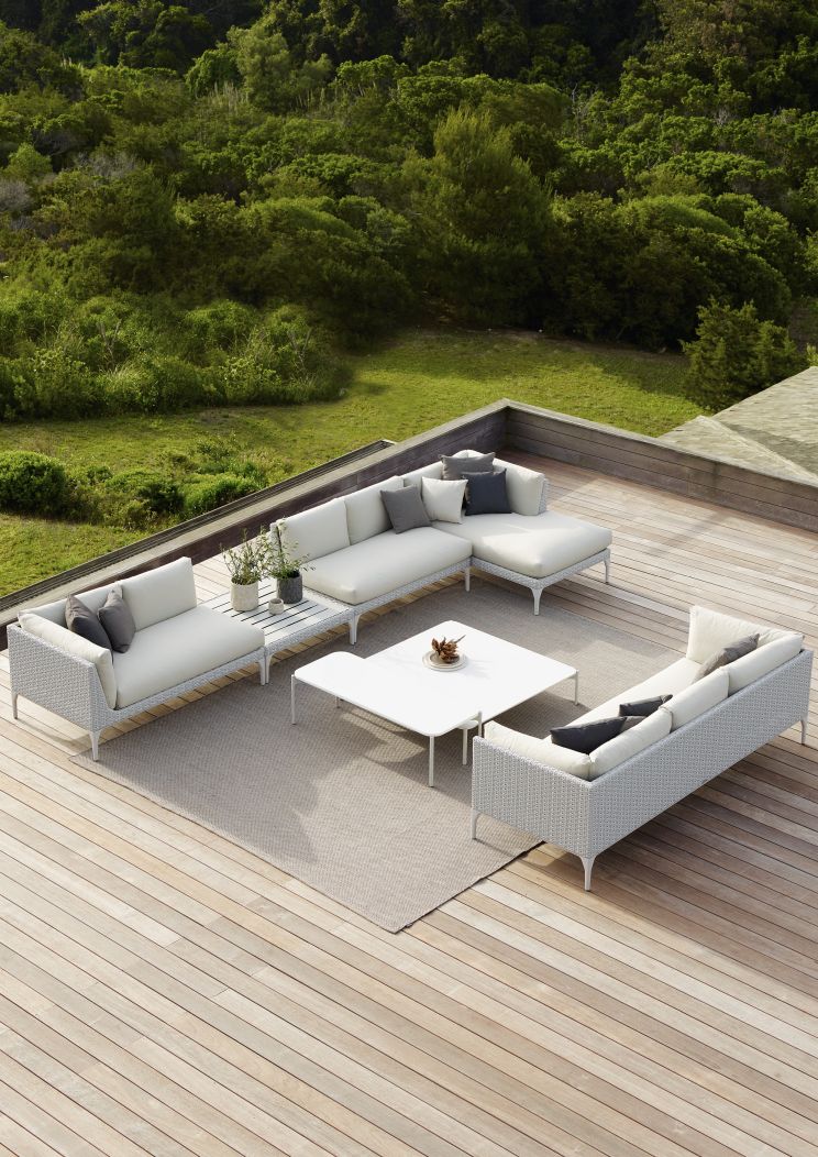 Izon Beistelltisch von Dedon, rechteckig, aus Rattan, Teil einer Lounge-Gruppe im Freien.