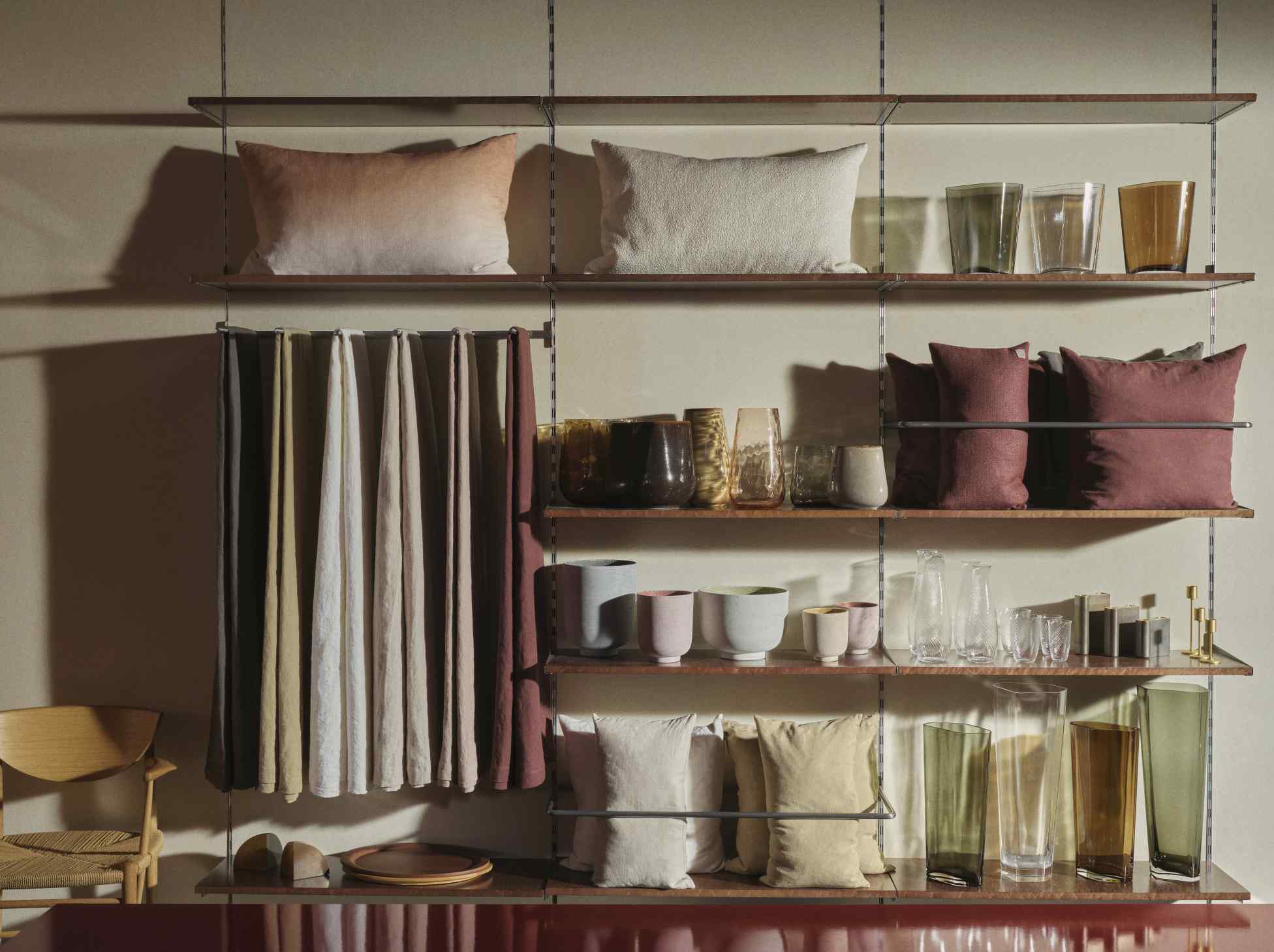 Detailaufnahme des AndTradition Kerzenhalters SC57-SC59 auf einem Regal mit Wohnaccessoires. Dekorative Kerzenständer und Vasen.