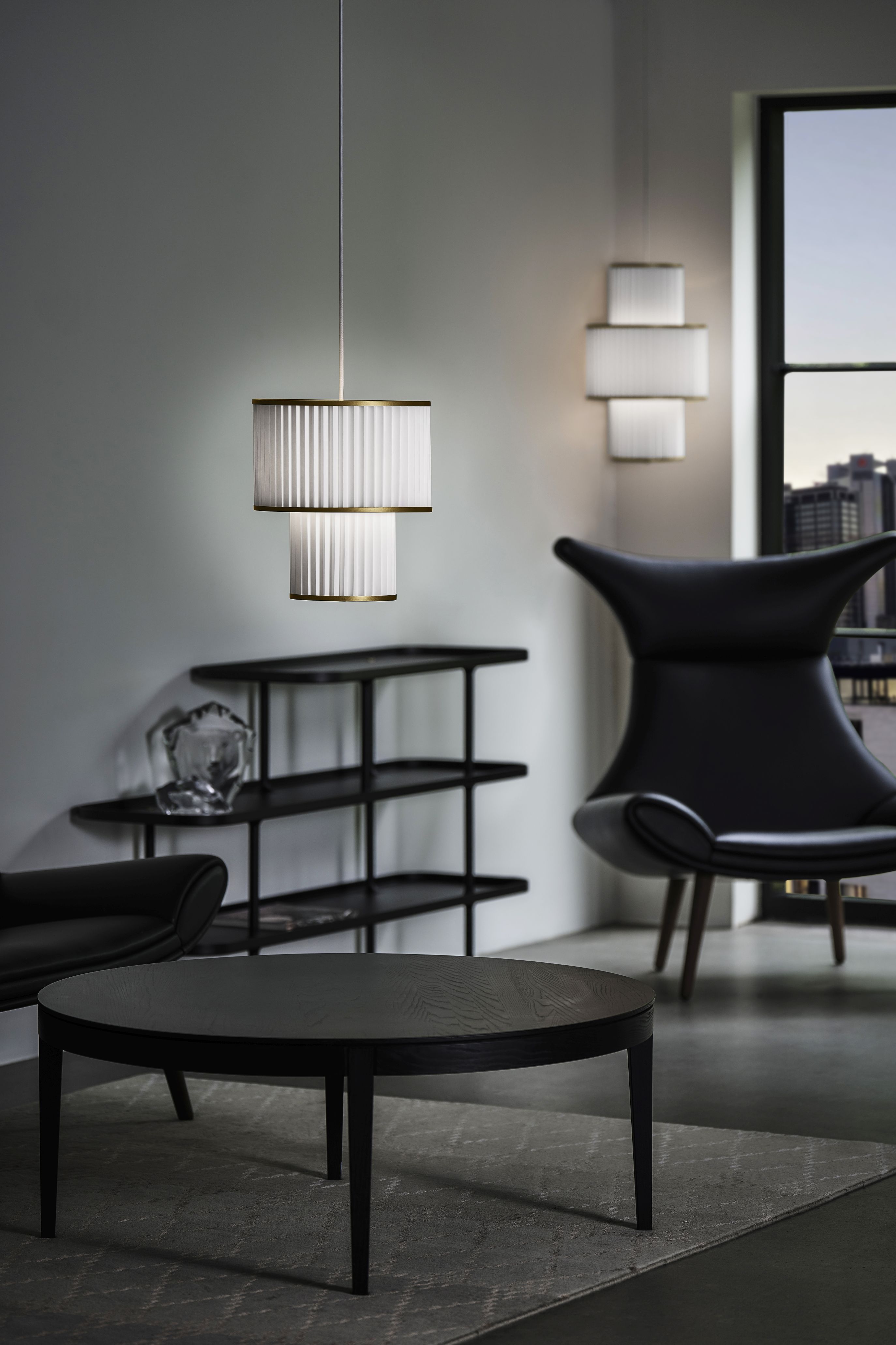 Plivello Pendelleuchte von Le Klint: Elegante, zweistufige Hängelampe mit plissiertem Lampenschirm im modernen Wohnzimmer.