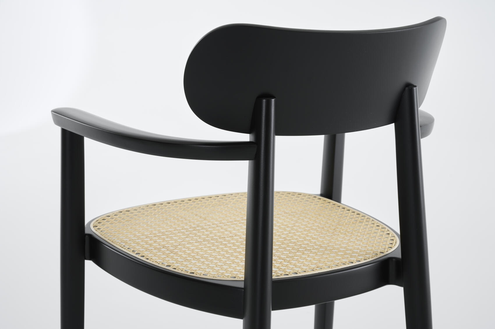 Ansicht von hinten: Schwarzer 118 FV Holzstuhl mit Armlehnen und Wiener Geflecht Sitzfläche.