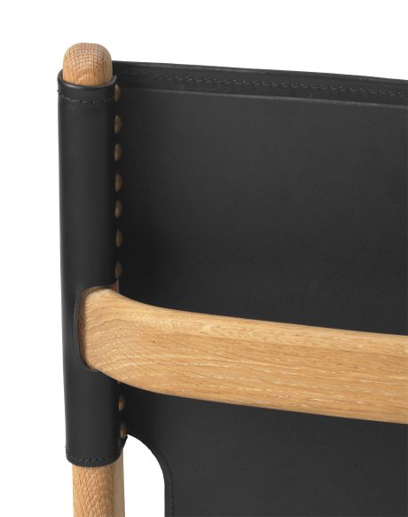 Detailansicht: Saxe Chair mit geöltem Eichenholzrahmen und schwarzem Lederbezug von Audo.