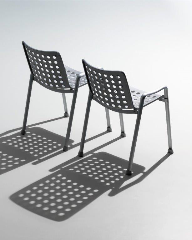 Zwei graue Landi Stühle von Vitra mit runden Löchern im Sitz und Rückenlehne.