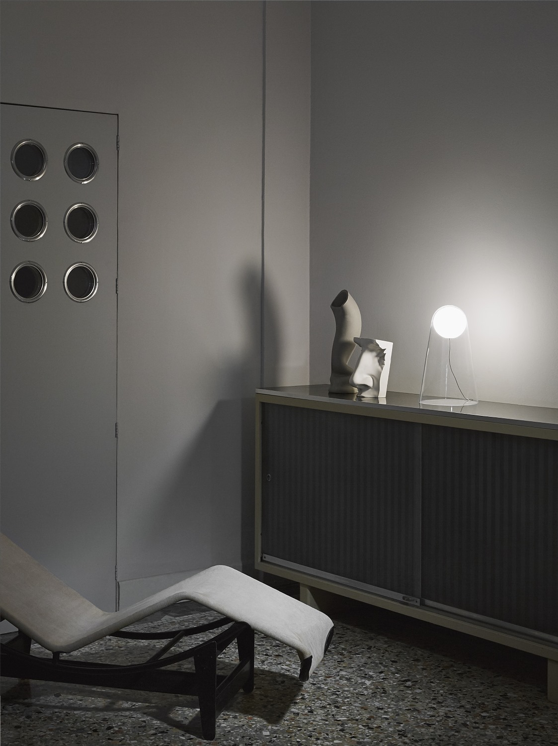 Satellight Tischleuchte von Foscarini, moderne Designleuchte mit weißem Diffusor auf einer Kommode.