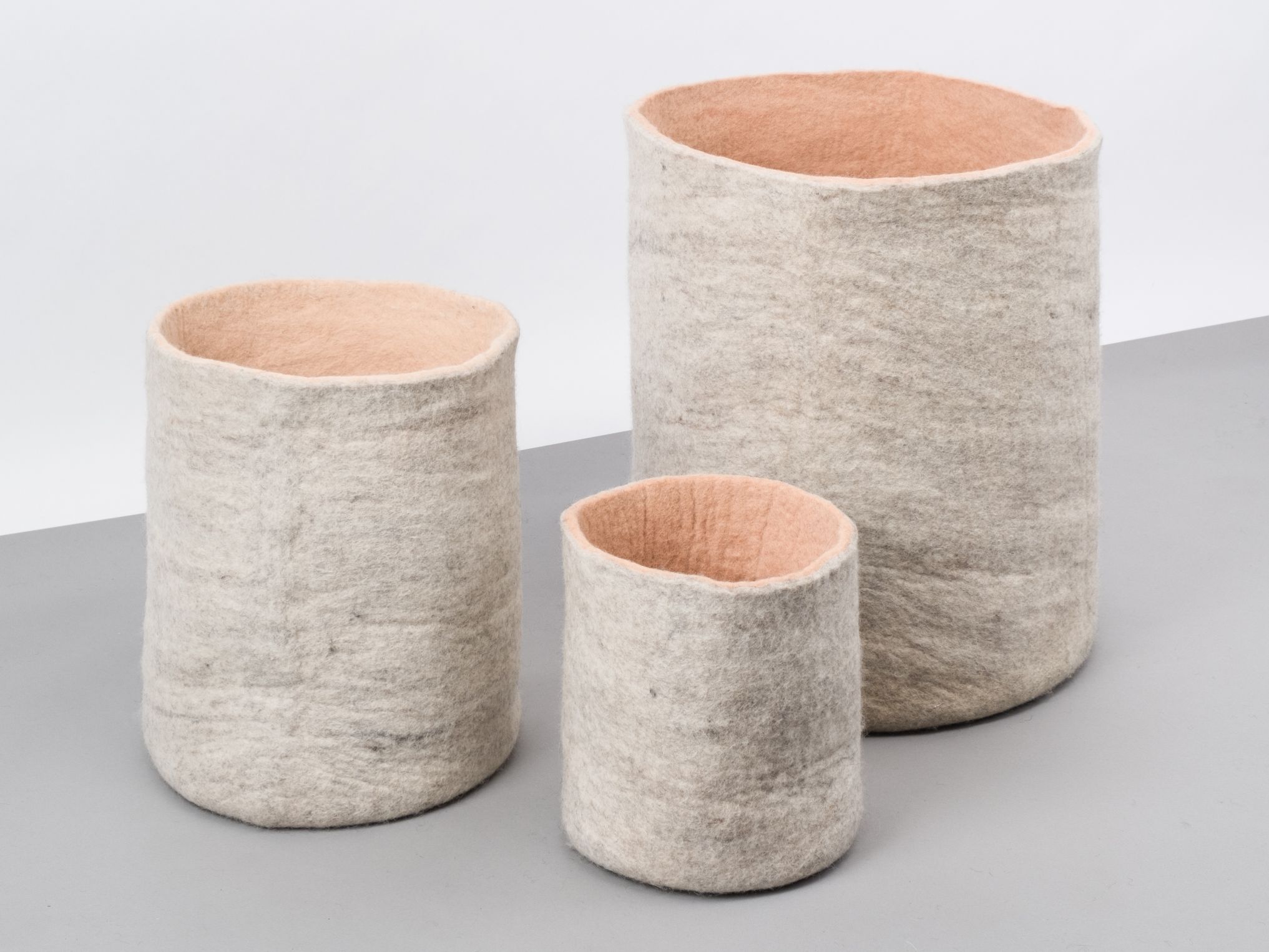 Drei graue Filzkörbe der Marke myfelt mit rosa Innenseite, verschiedene Größen. Aufbewahrungskorb aus Filz.