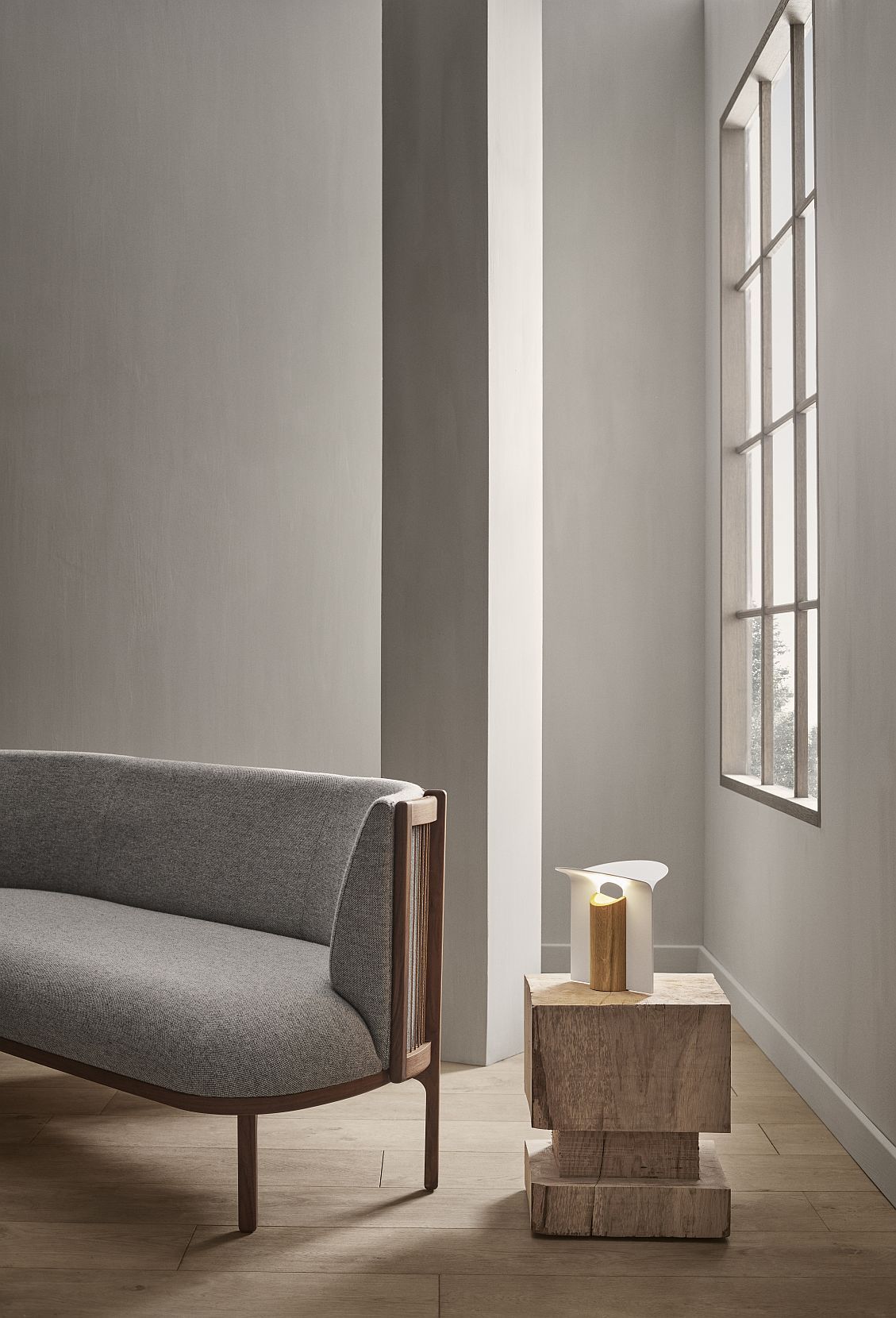 RF200 Petal Lamp Tischleuchte von Carl Hansen & Søn auf Holzsockel neben Sofa.