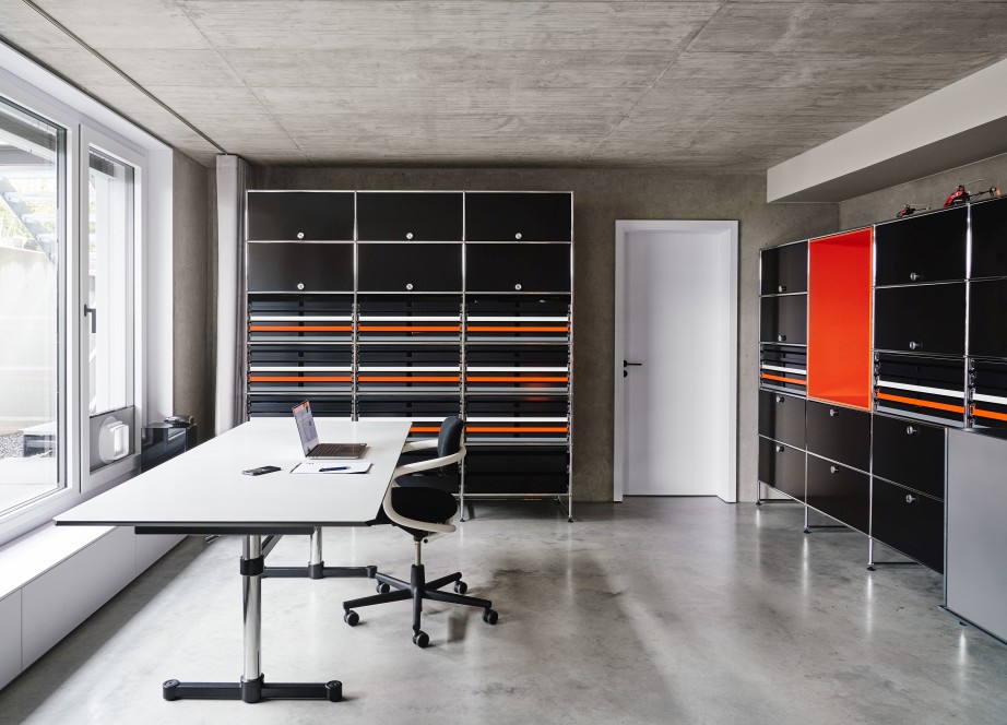 USM Haller Kitos M Schreibtisch in Nero Linoleum mit Laptop und Büromöbeln im modernen Büro.