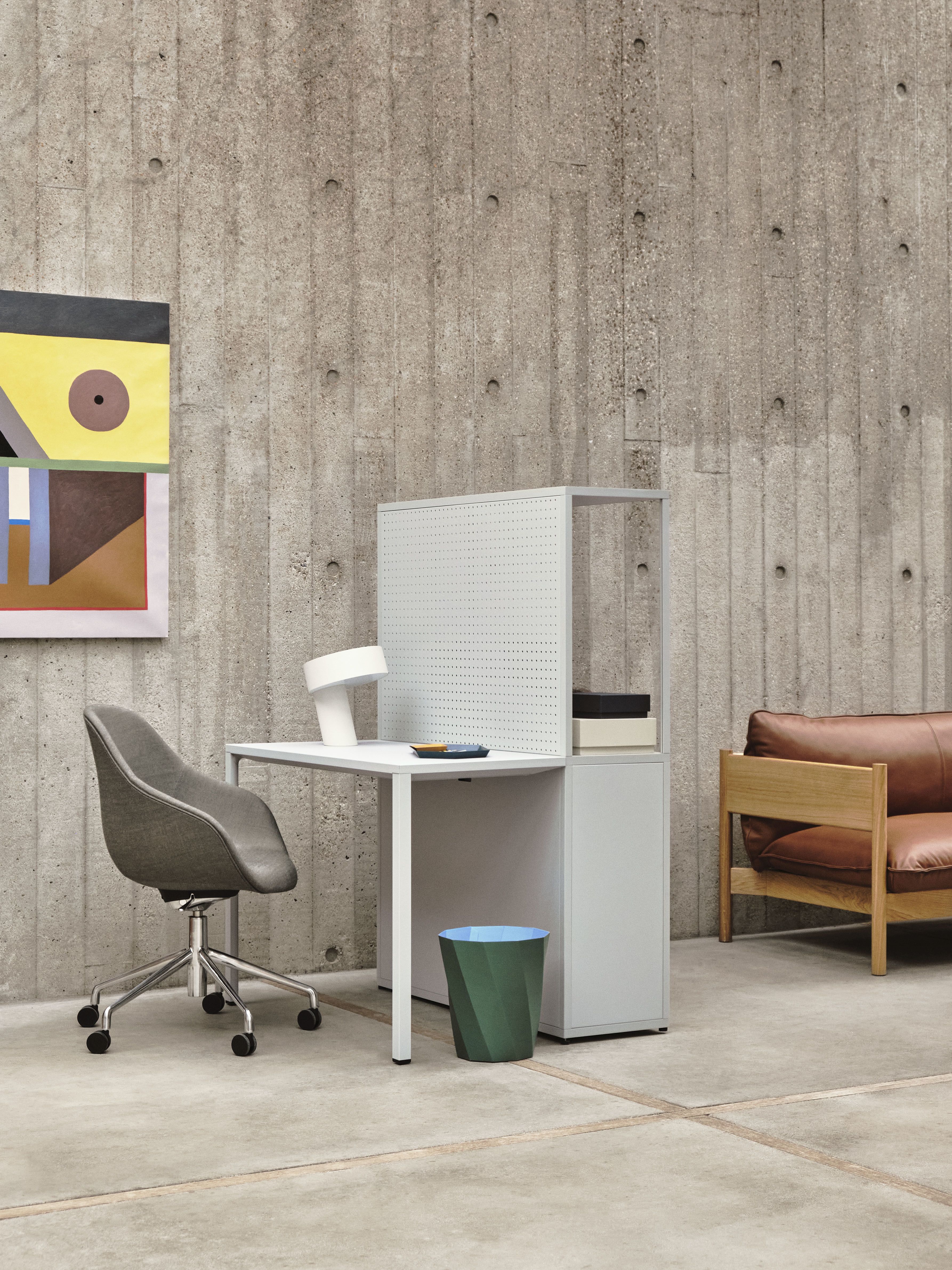 Modernes Büro mit Schreibtisch, Bürostuhl und einem Arbour Sofa von Hay im Hintergrund.