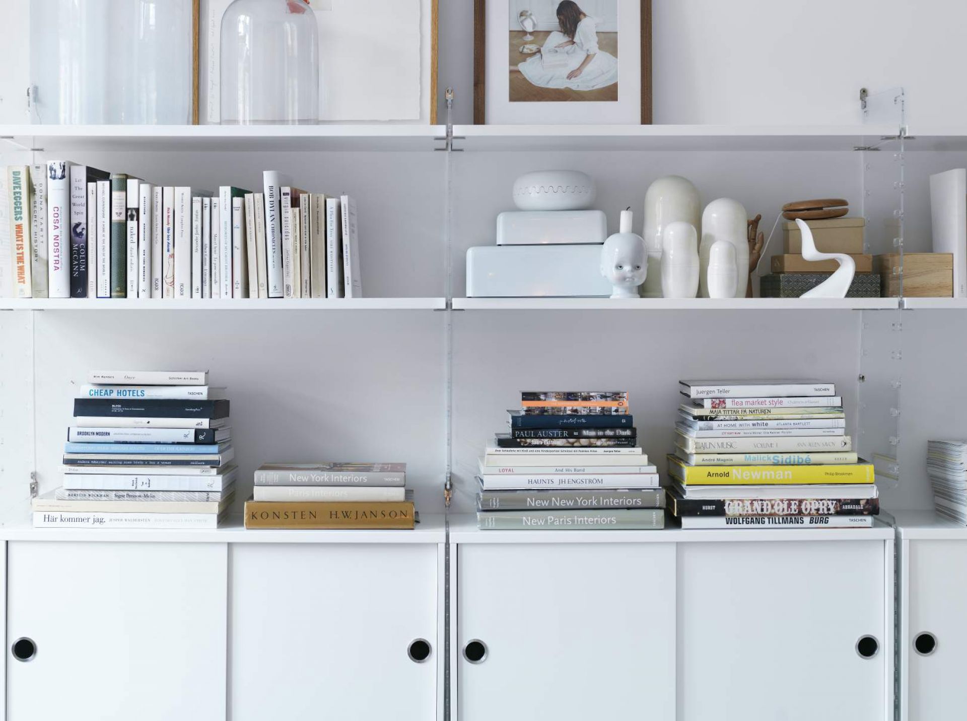 Weißes String Regalsystem mit Büchern und Deko-Objekten. Wandregal für Wohnzimmer und Büro.