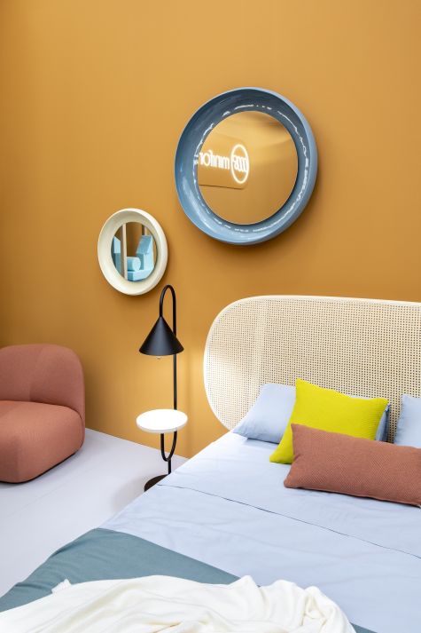 Runder Coque Spiegel von Miniforms mit blauem Keramikrahmen an ockerfarbener Wand.