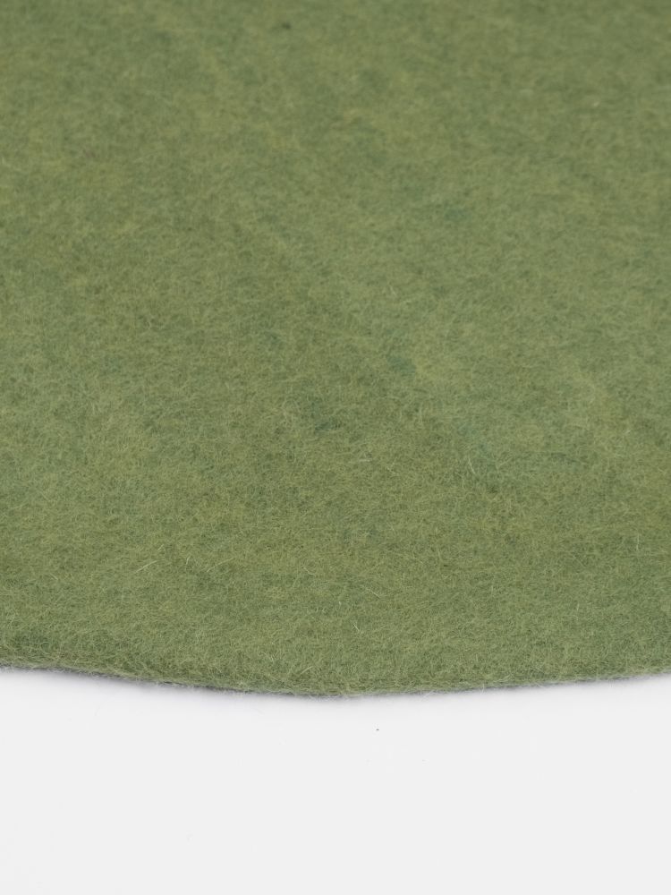 Detailaufnahme: Grüner, runder Filzteppich (myfelt) mit feiner Textur. Ideal als Wohnaccessoire und Teppich.
