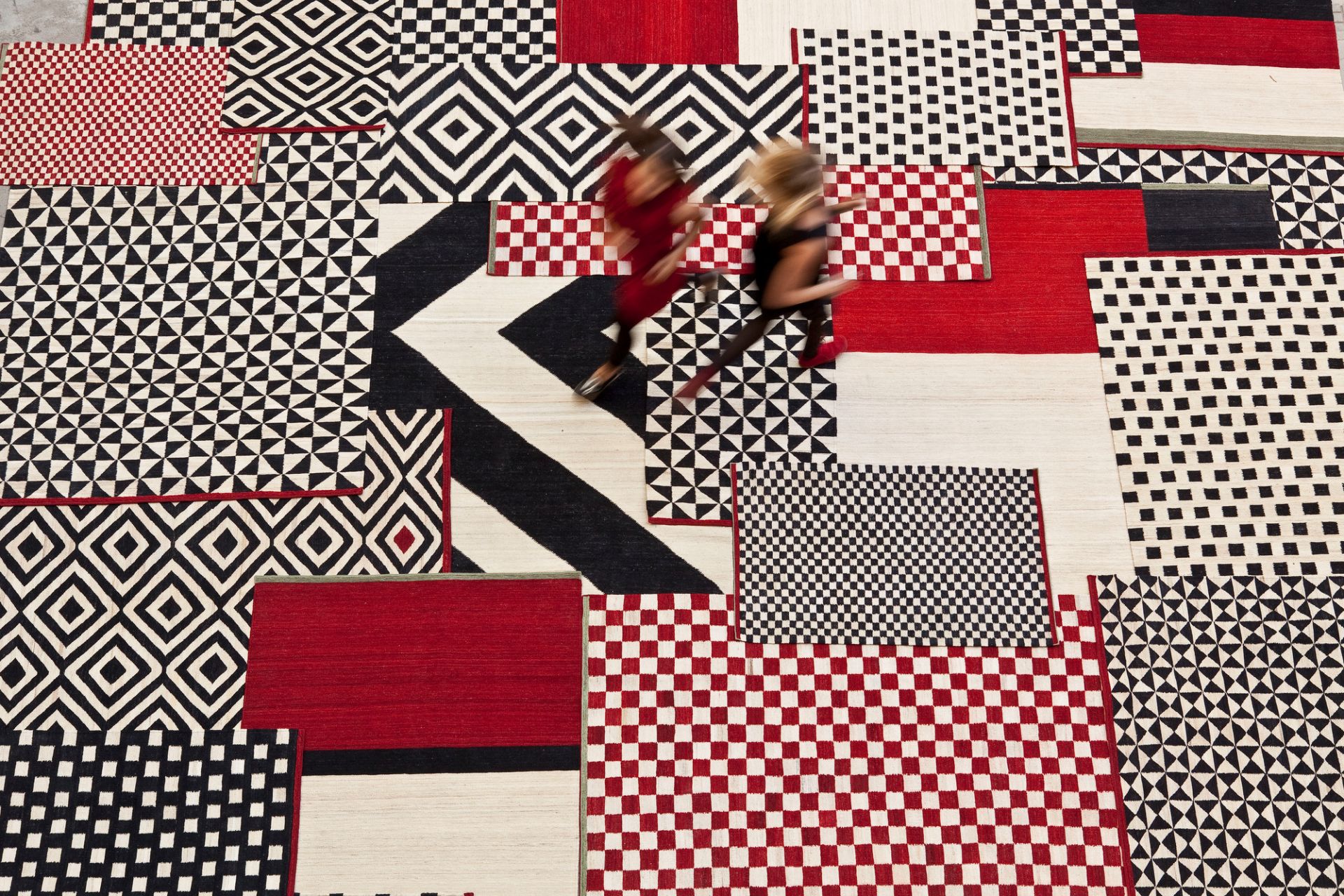 Ansicht von oben: Nanimarquina Mélange Teppich mit geometrischen Mustern in Rot, Schwarz und Weiß.