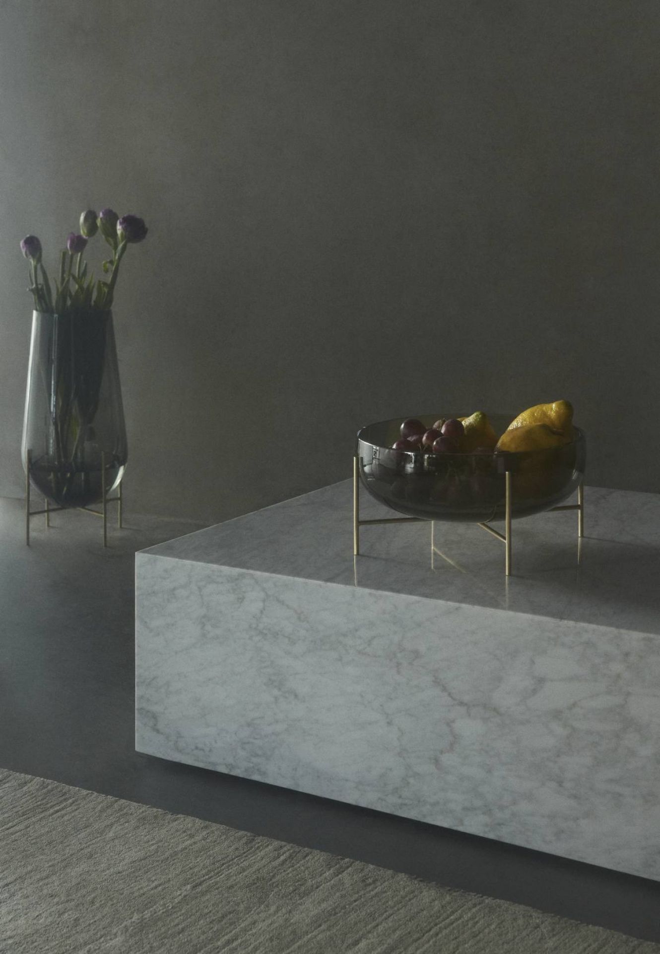 Échasse Bowl Schale von Audo: Glas Obstschale mit goldenem Gestell auf Marmortisch, moderne Dekoration.