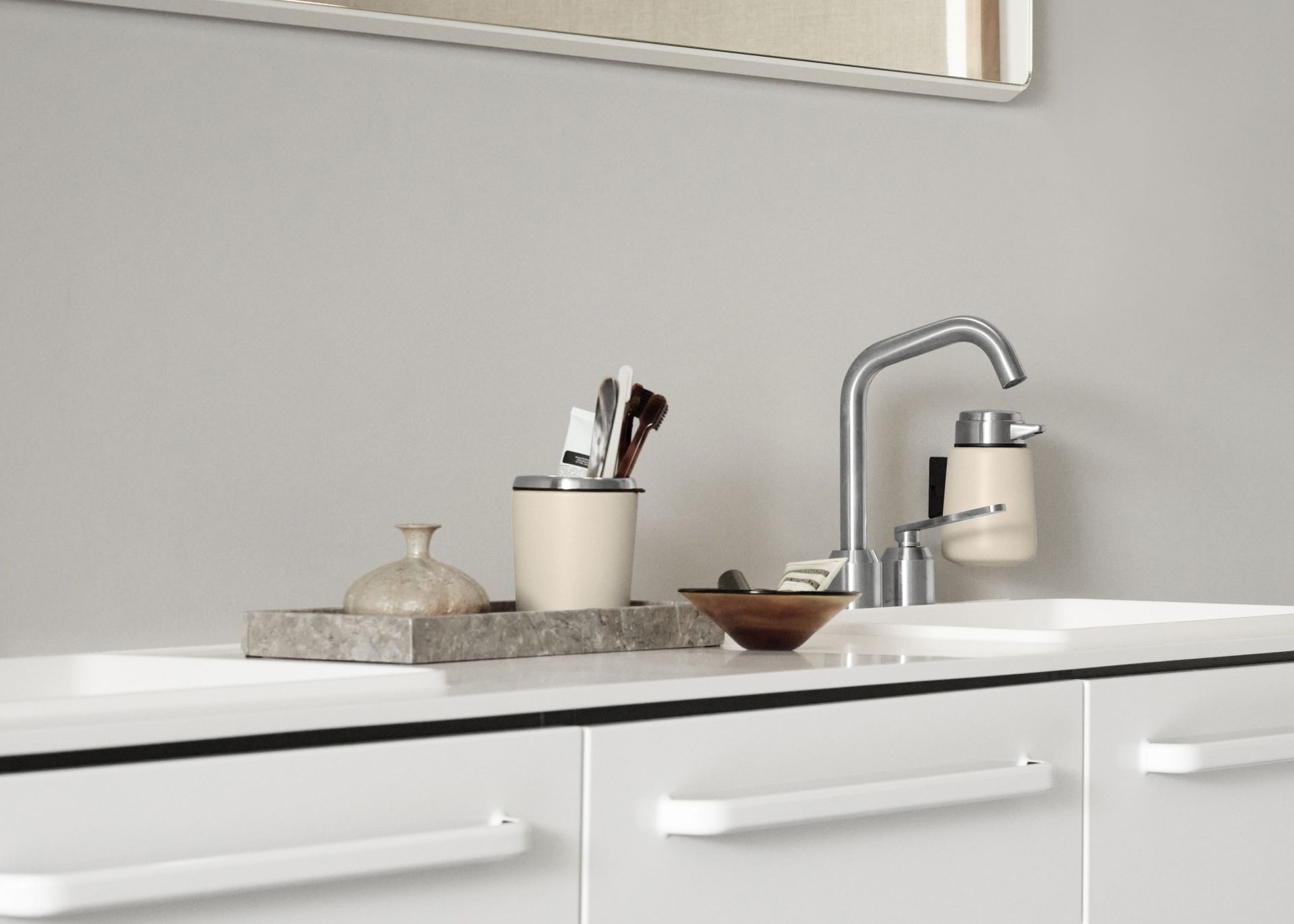 Beiger Vipp Seifenspender im modernen Badezimmer, neben Armatur und Accessoires auf weißem Waschtisch.