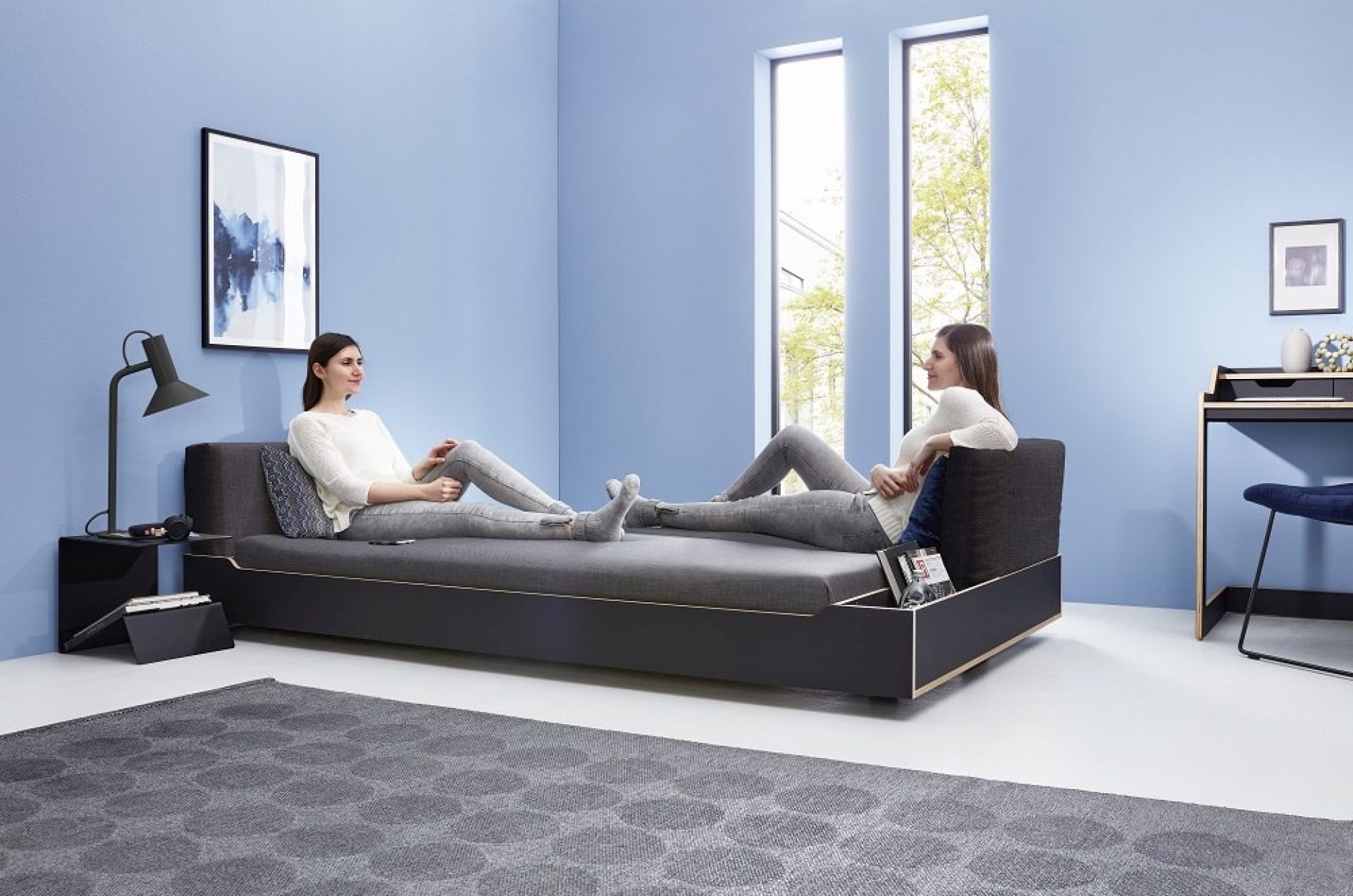 Maude Bett von Müller Möbelwerkstätten: Modernes Funktionsbett mit zwei Personen im hellen Raum.