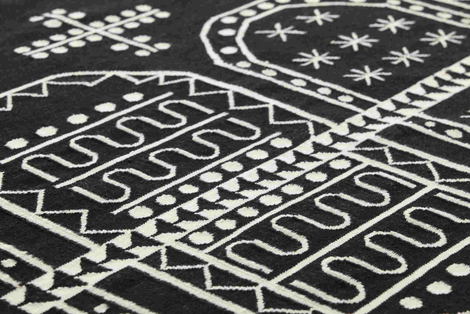 Detailaufnahme des Kilim Teppichs mit geometrischen Mustern in Schwarz und Weiß.
