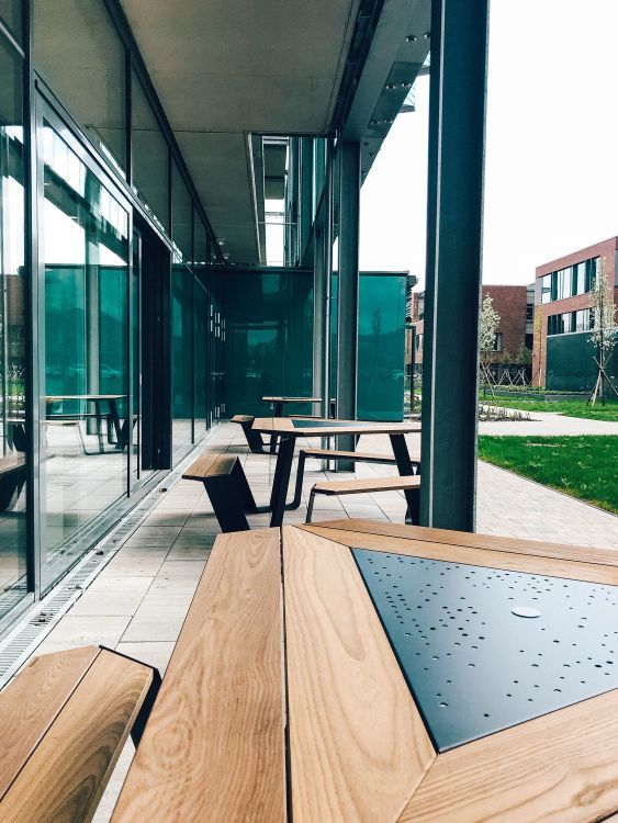 Anker Picknicktisch: Moderner Outdoor-Tisch mit Holzsitzen und Metallgestell für den Außenbereich.