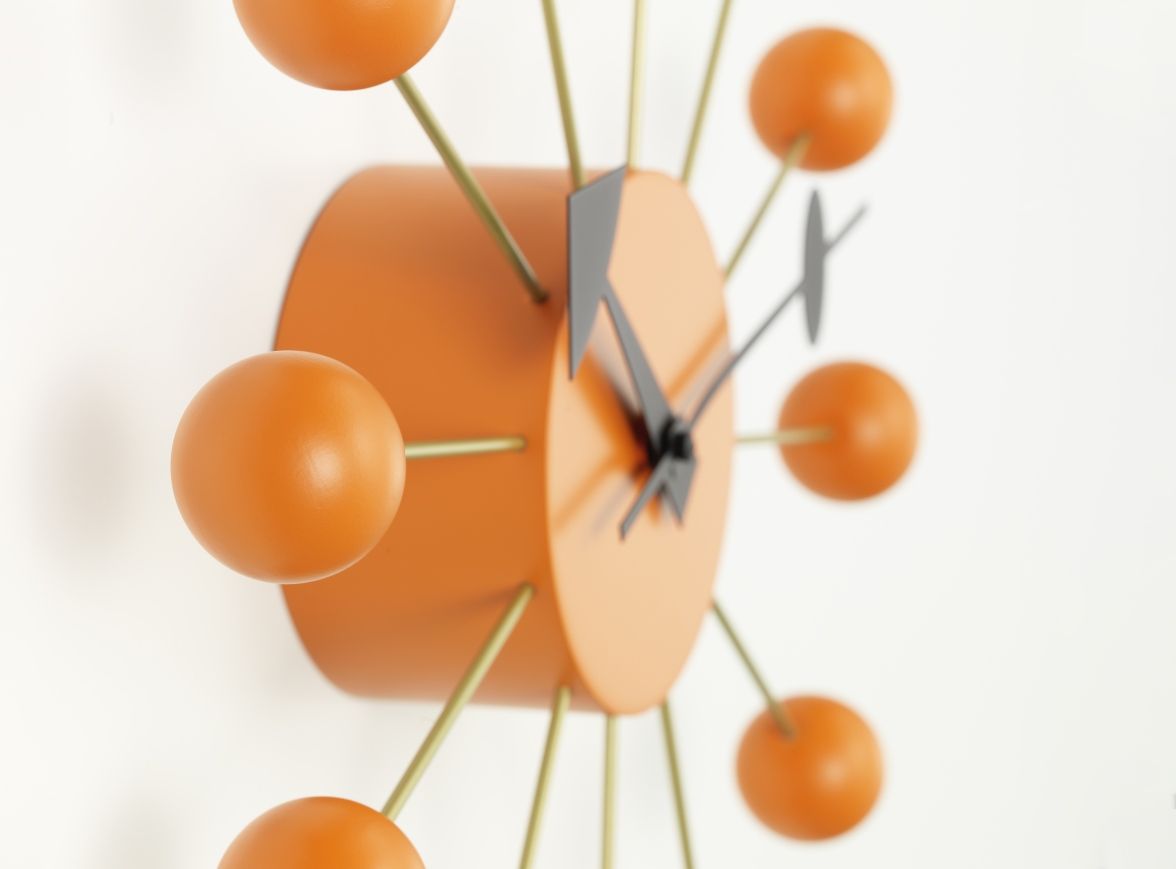 Detailansicht der orangefarbenen Ball Clock Wanduhr von Vitra, modernes Design für Wohnzimmer und Büro.