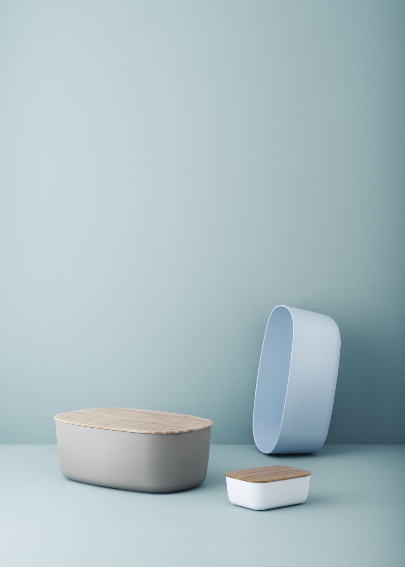 Drei Brotkästen in Grau, Weiß und Blau mit Holzdeckel, darunter der Box-It Brotkasten.