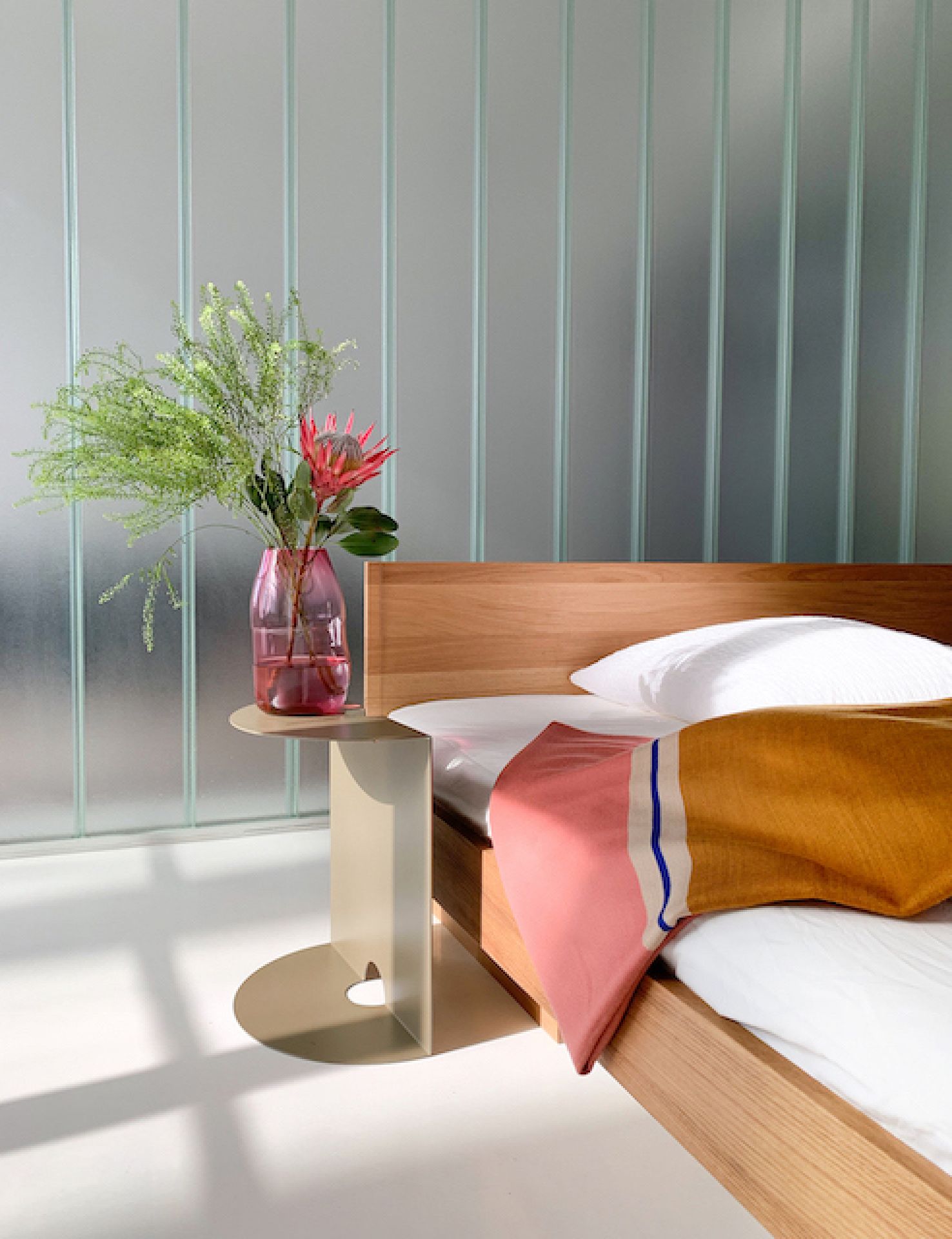 ZIANS Bett Large mit Kopfteil aus Eiche, gewachst, mit Nachttisch und Textilien im Schlafzimmer.