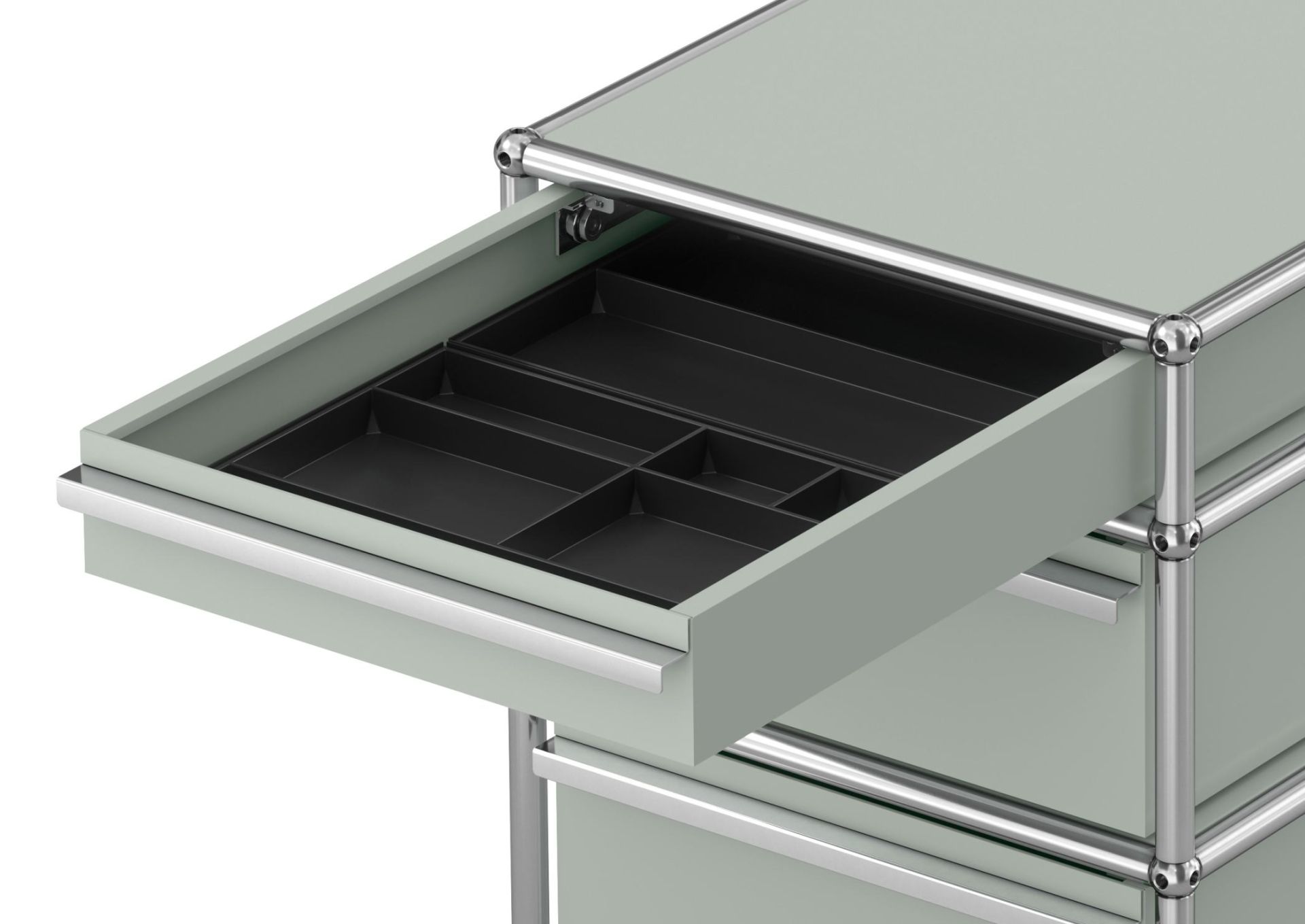 Detailaufnahme USM Haller Rollcontainer mit drei Schubladen in Lichtgrau, eine Schublade ist geöffnet.