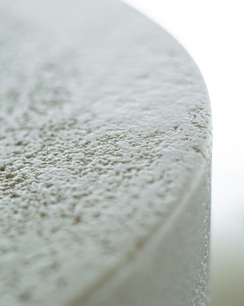 Detailaufnahme: Ethnicraft Couchtisch Elements mit Microzement-Oberfläche in Off-White. Rundes Design, moderne Wohnzimmermöbel.