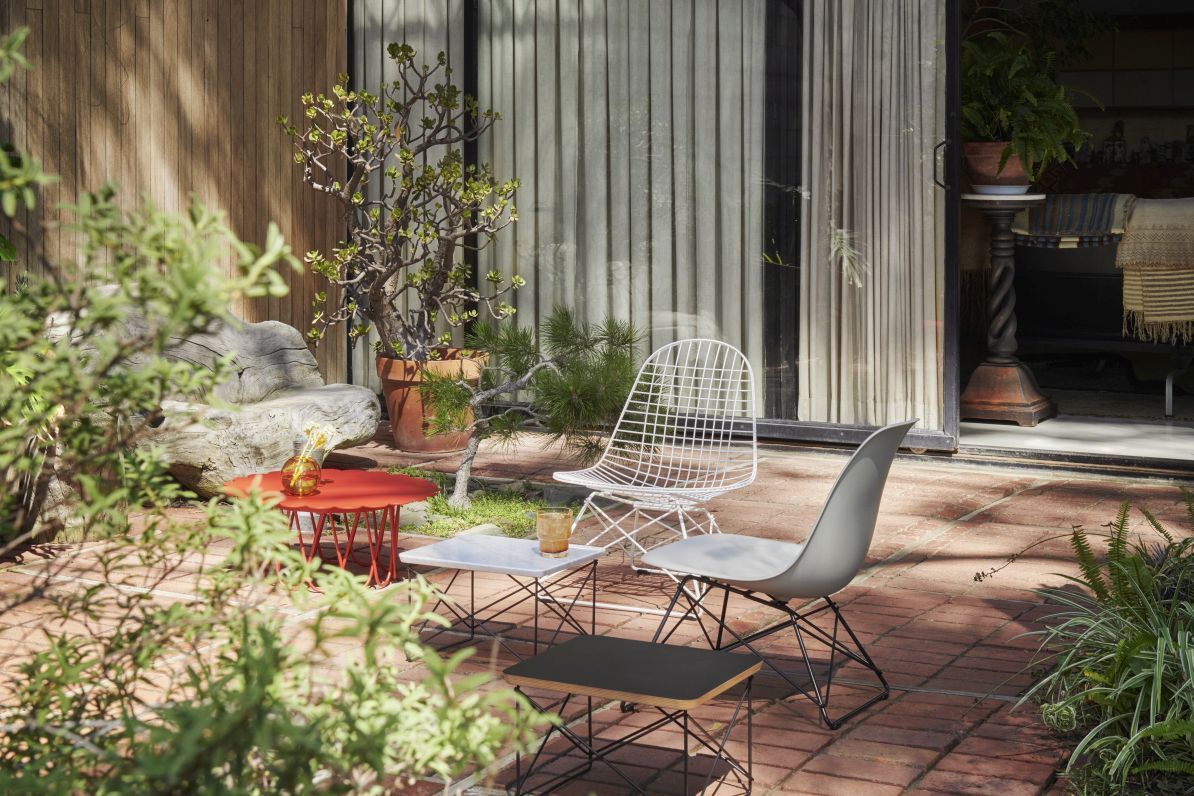 Eames Plastic Side Chair (Vitra) in Grau auf einer Terrasse mit weiteren Designermöbeln.