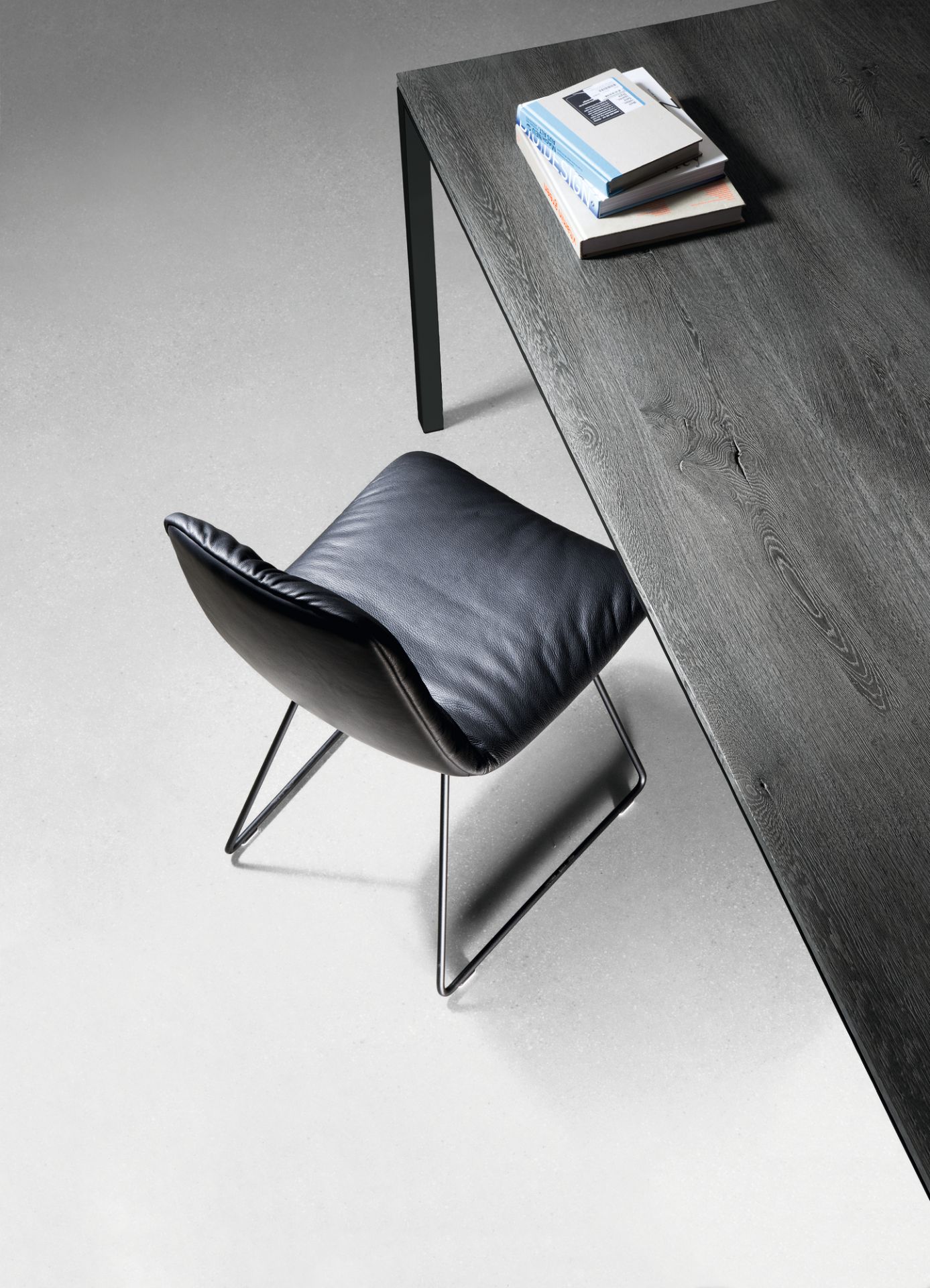 Detailaufnahme: Janua S 600 Tisch Eiche geölt mit Stuhl und Büchern, modernes Möbeldesign.