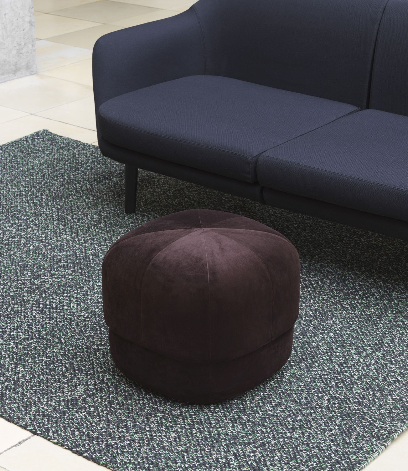 Brauner Circus Pouf Small Hocker von Normann Copenhagen auf einem Teppich, neben einem Sofa.