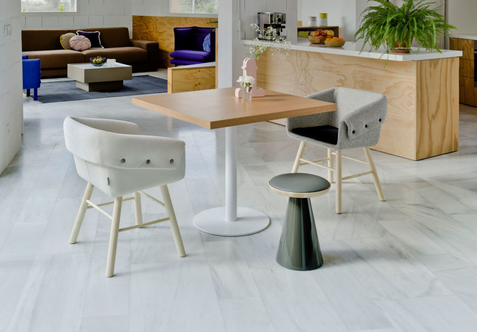 Pion Hocker Limone von Sancal, grauer Barhocker und weißer Sessel an Esstisch.