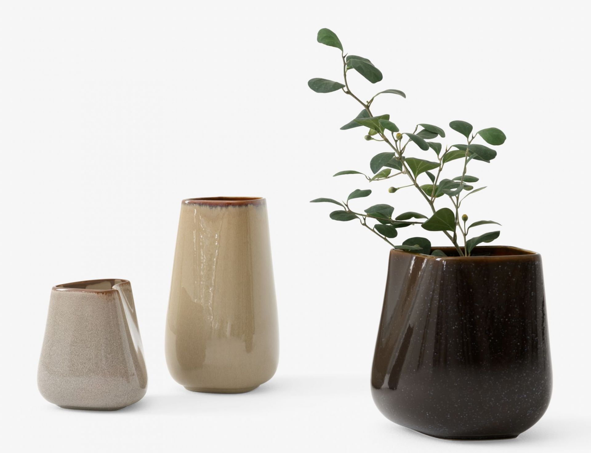 Drei Keramikvasen von AndTradition in Beige und Braun, eine mit grünen Zweigen. Dekorative Einzelstücke.