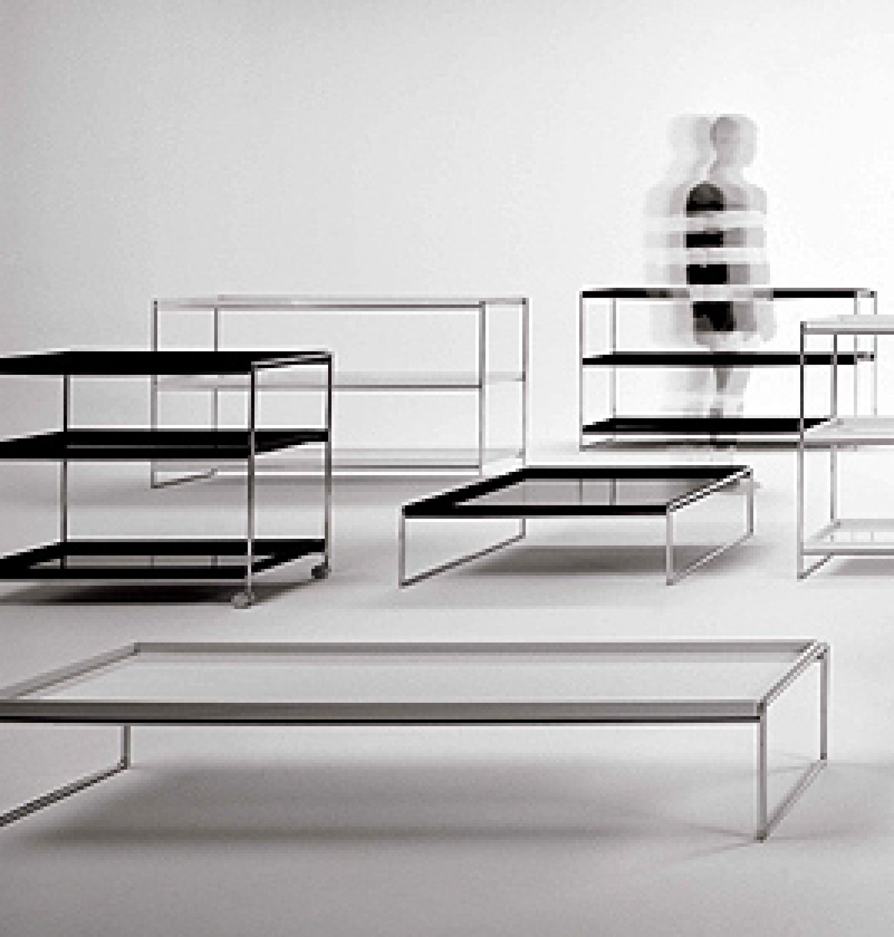 Trays Regal von Kartell: Mehrere moderne, minimalistische Regale und Tische mit Ablageflächen in Schwarz und Weiß.