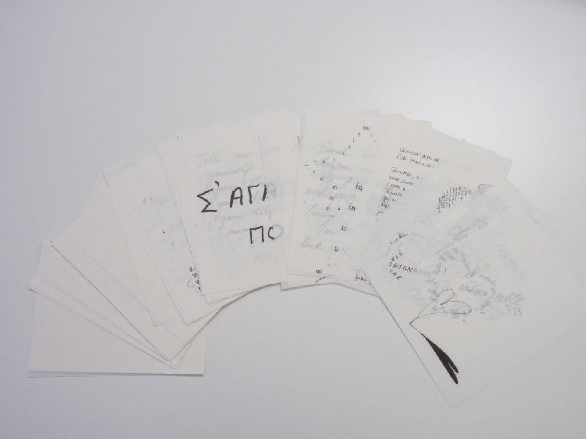 Zettelsatz für Ingo Maurer Zettel Z 5 Leuchte: Beschriebene Blätter liegen fächerförmig auf weißem Hintergrund.